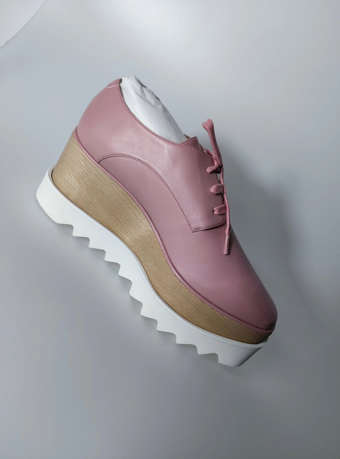 Sneaker plateforme Elyse rose pour femme, de Stella McCartney, avec semelle épaisse blanche et détails en bois.