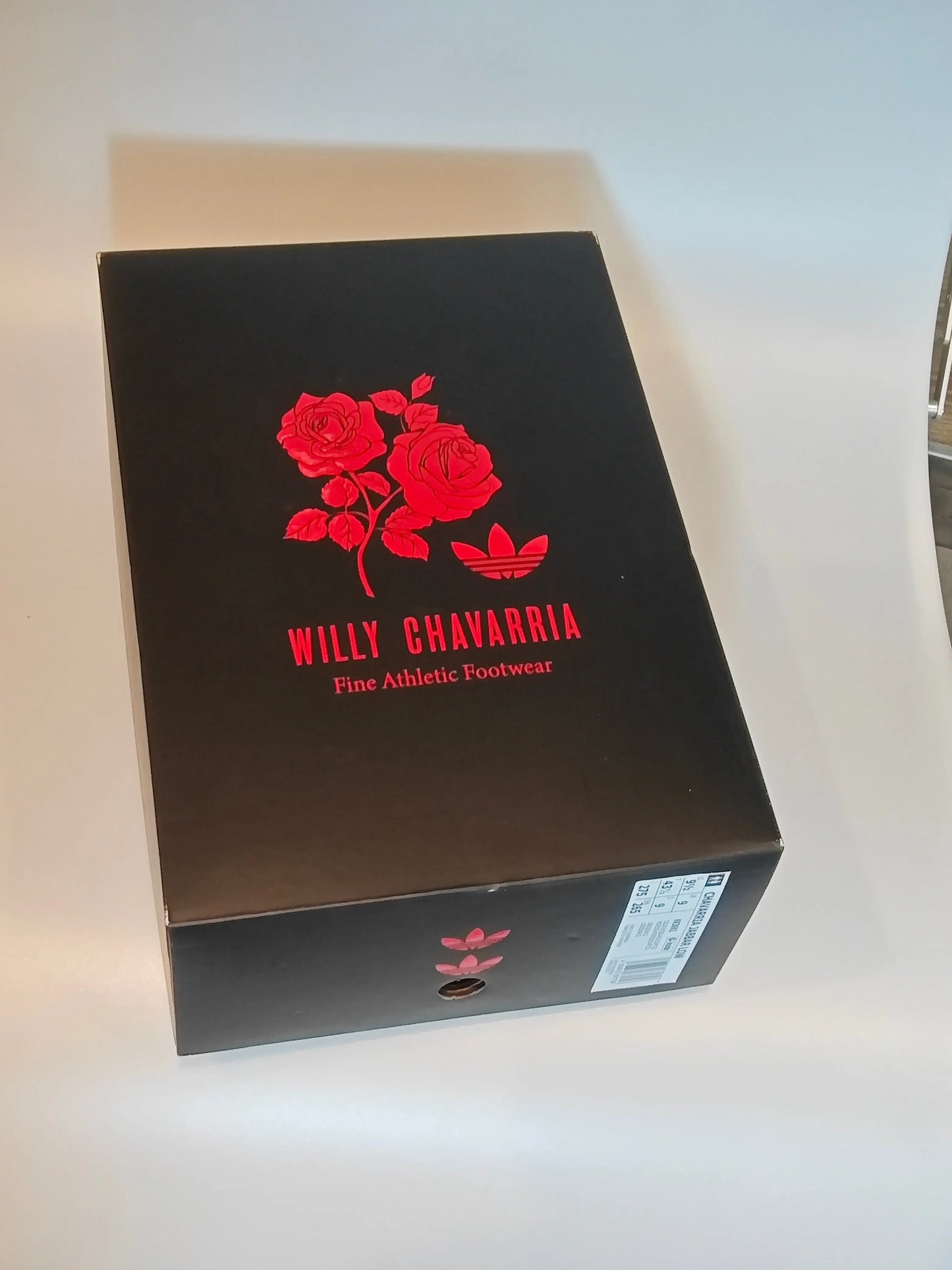Boîte à chaussures de basket noir, Adidas par Willy Chavarria, avec motif de roses rouges et logo trèfle.