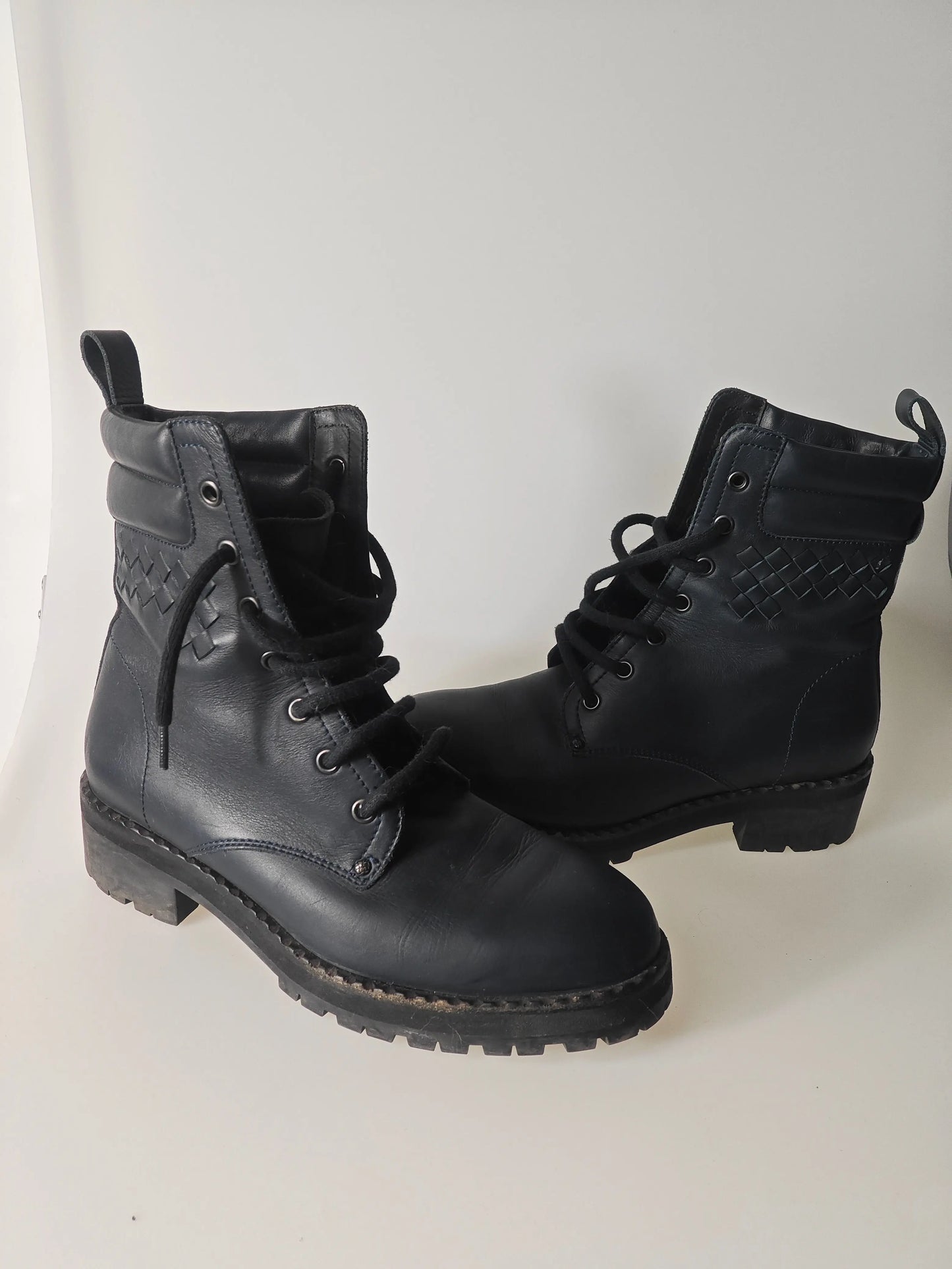 Bottines en cuir noir de Bottega Veneta avec détail tressé sur le côté supérieur et lacets noirs.