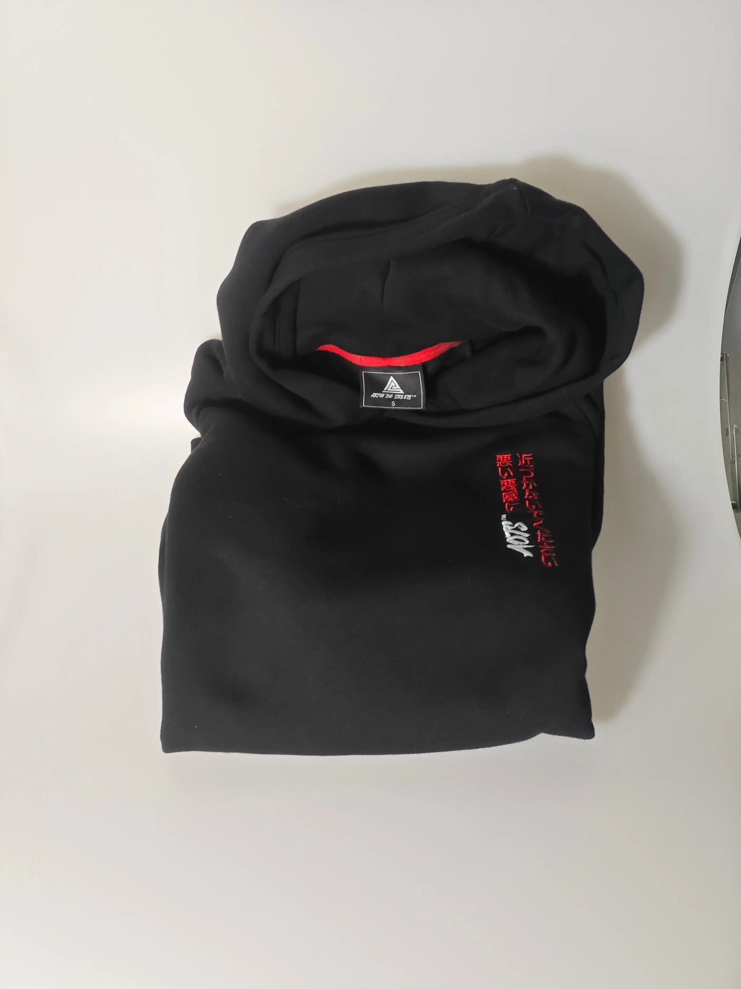 Sweat à capuche noir de Arts Of The Streets avec une broderie japonaise rouge et blanche sur le devant.