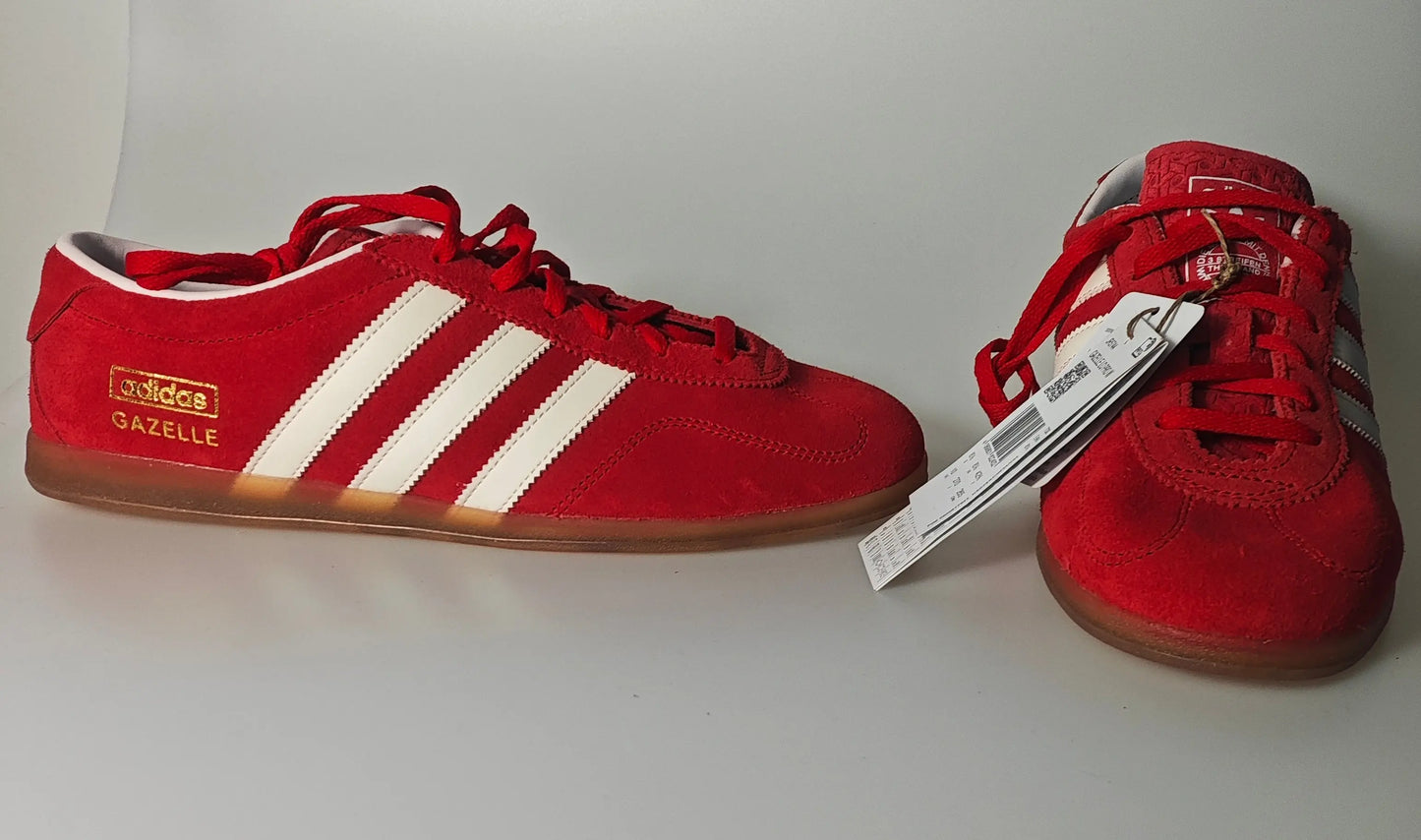 Baskets rouges en daim de Adidas, neuves avec étiquettes, avec les trois rayures blanches emblématiques.