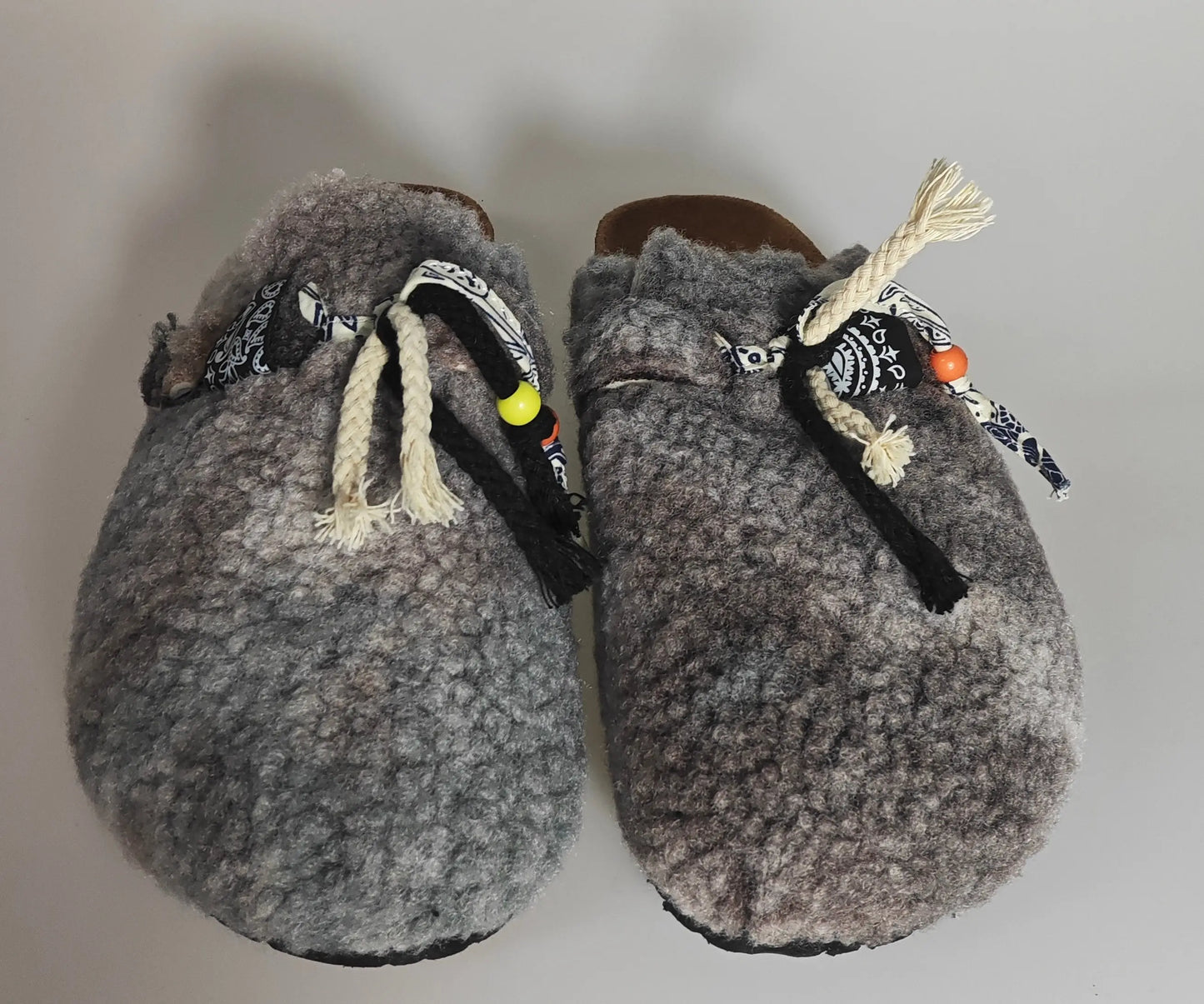 Chaussons fourrés gris de Diabless avec cordons décoratifs et perles colorées.