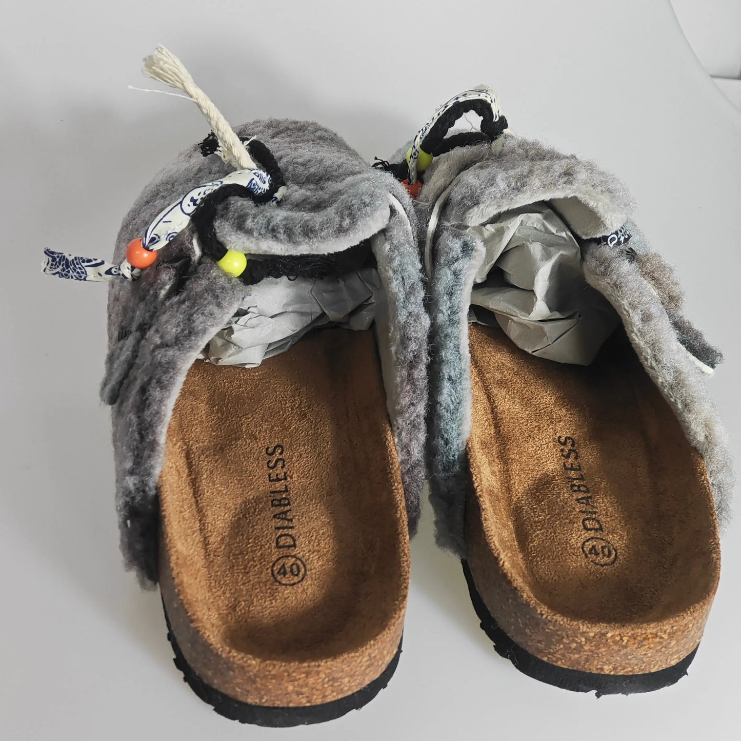 Mules doublées grises de Diabless, avec fourrure duveteuse et ornements décoratifs à perles.