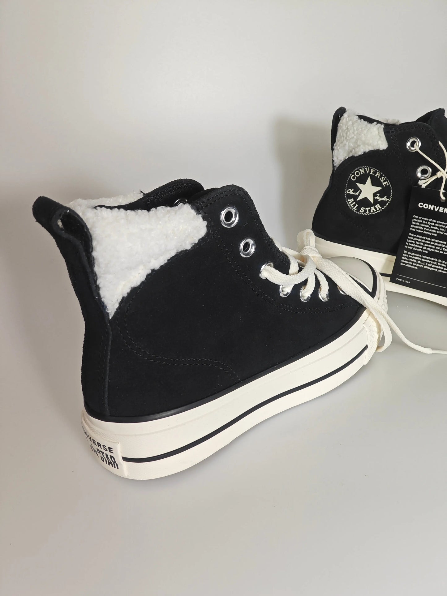 Baskets montantes noires doublées de fourrure par Converse, avec lacets blancs et semelle épaisse.