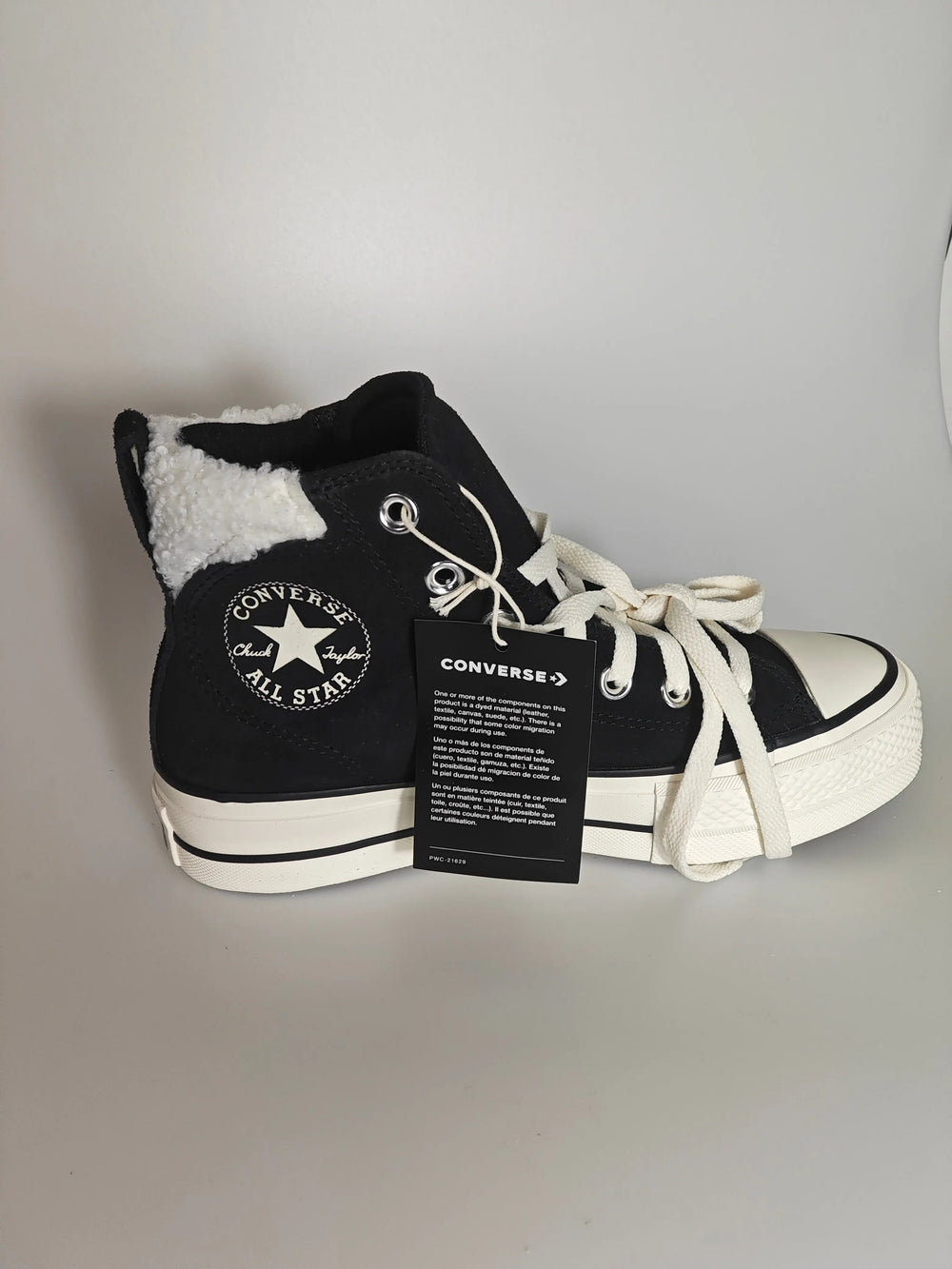 Baskets montantes en daim noir et doublure en fourrure de Converse, avec lacets blancs.