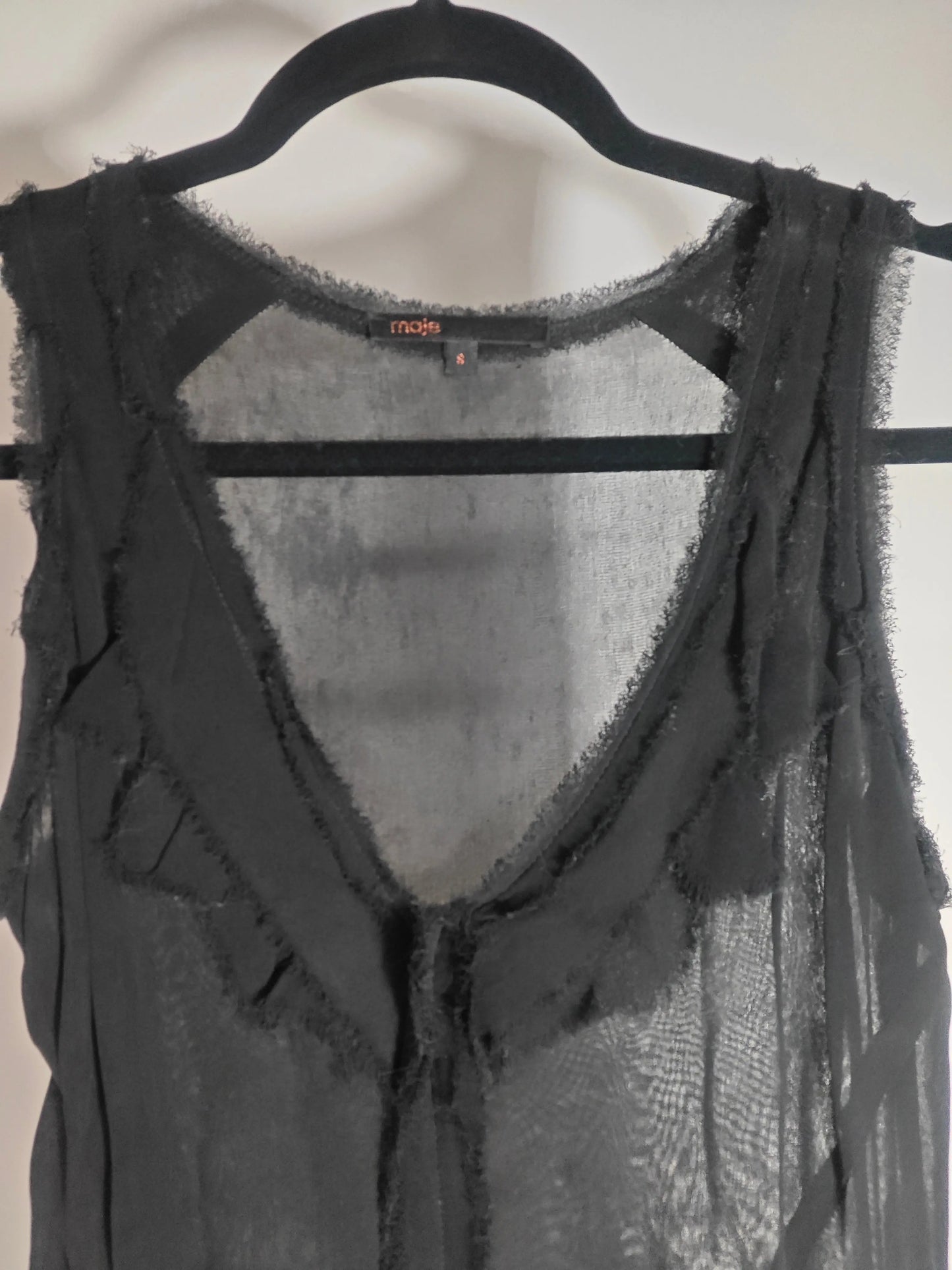 Robe noire fluide de Maje, style bohème chic avec détails de volants frangés.
