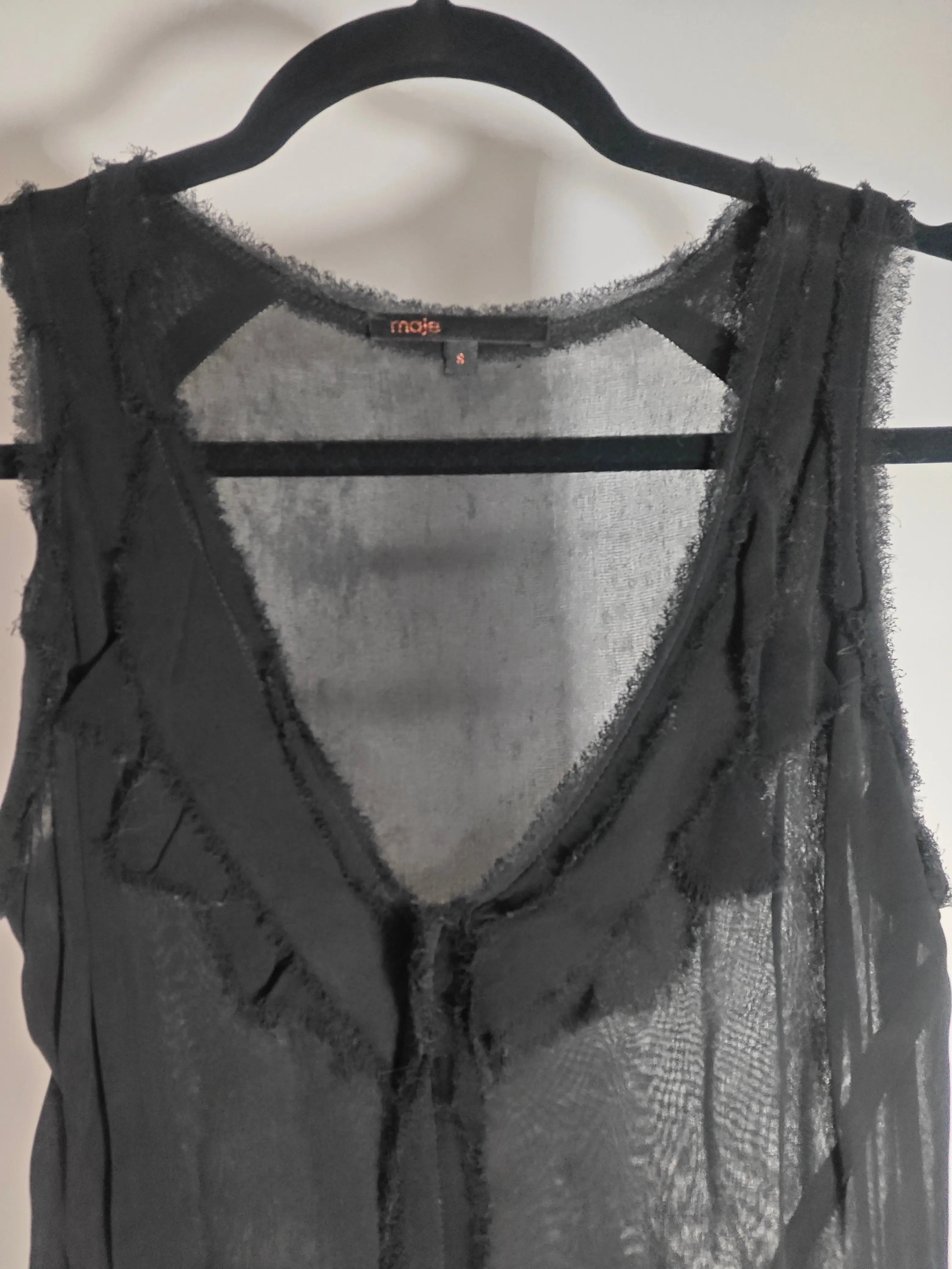 Robe noire fluide de Maje, style bohème chic avec détails de volants frangés.