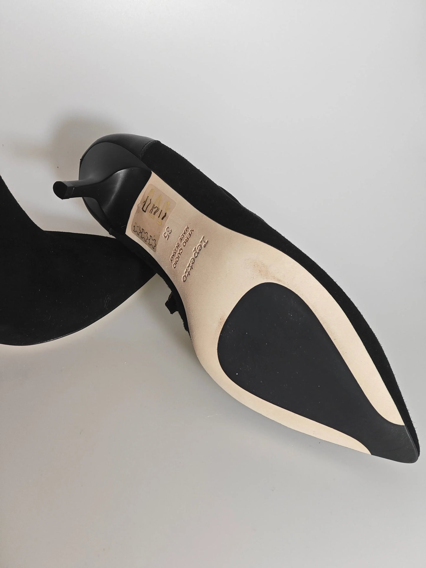 Bottines en daim noir par Repetto, présentant une semelle beige avec patch noir antidérapant.