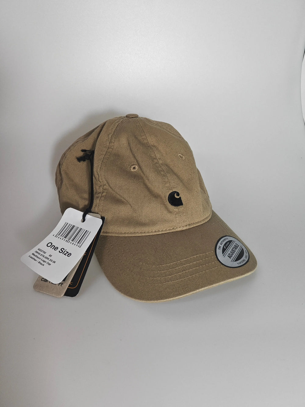 Casquette beige ajustable de Carhartt avec logo noir brodé et étiquette cartonnée.
