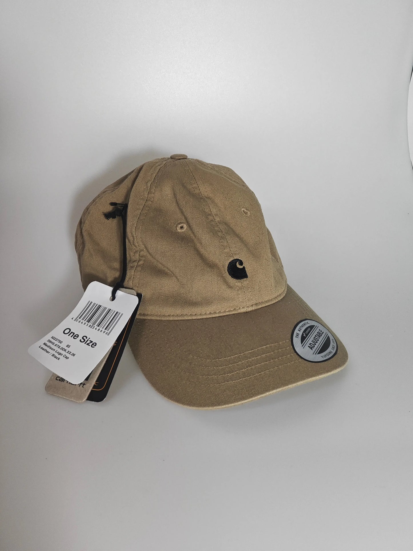 Casquette beige ajustable de Carhartt avec logo noir brodé et étiquette cartonnée.