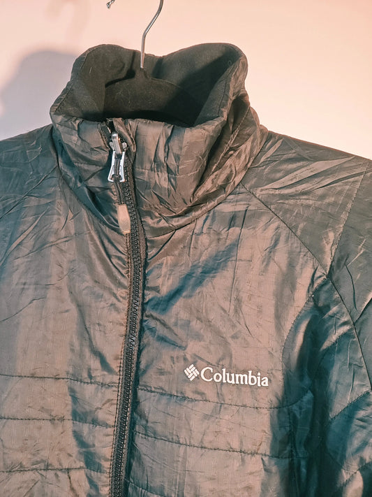 Veste noire matelassée de Columbia, avec une fermeture éclair pleine longueur et un col montant en polaire.