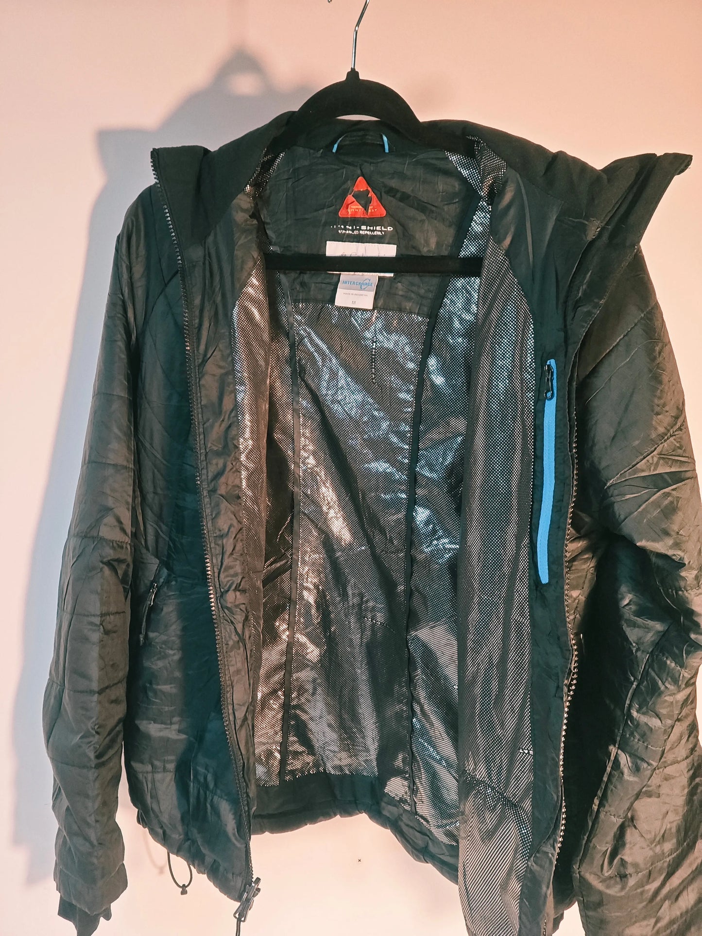 Veste noire Columbia Interchange Omni-Heat de Columbia, doublure réfléchissante argentée et détails bleus.