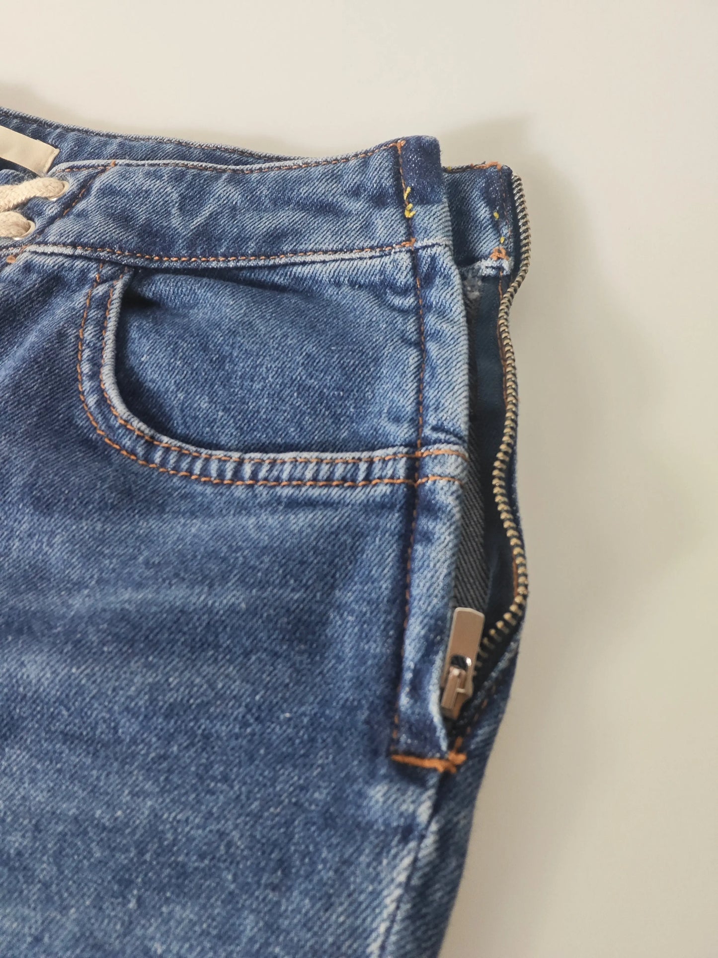 Jean bleu en denim de Maje, lacé sur le devant et doté d'une fermeture éclair latérale.