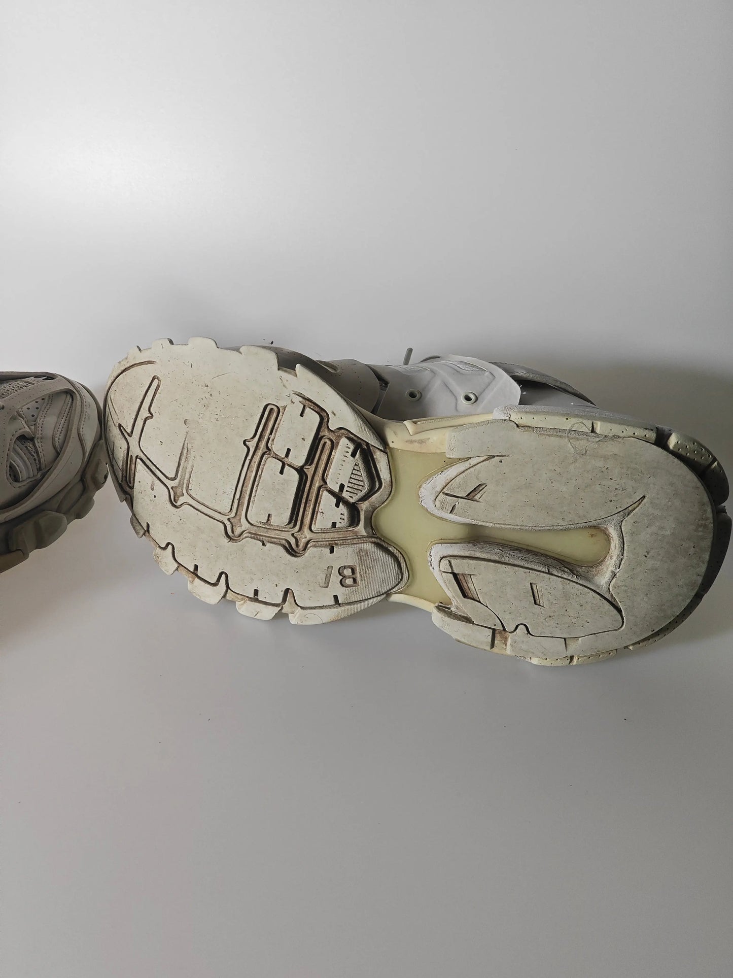 Baskets basses grises de Balenciaga, semelle texturée usée avec inscription 'BJ', sur fond blanc.