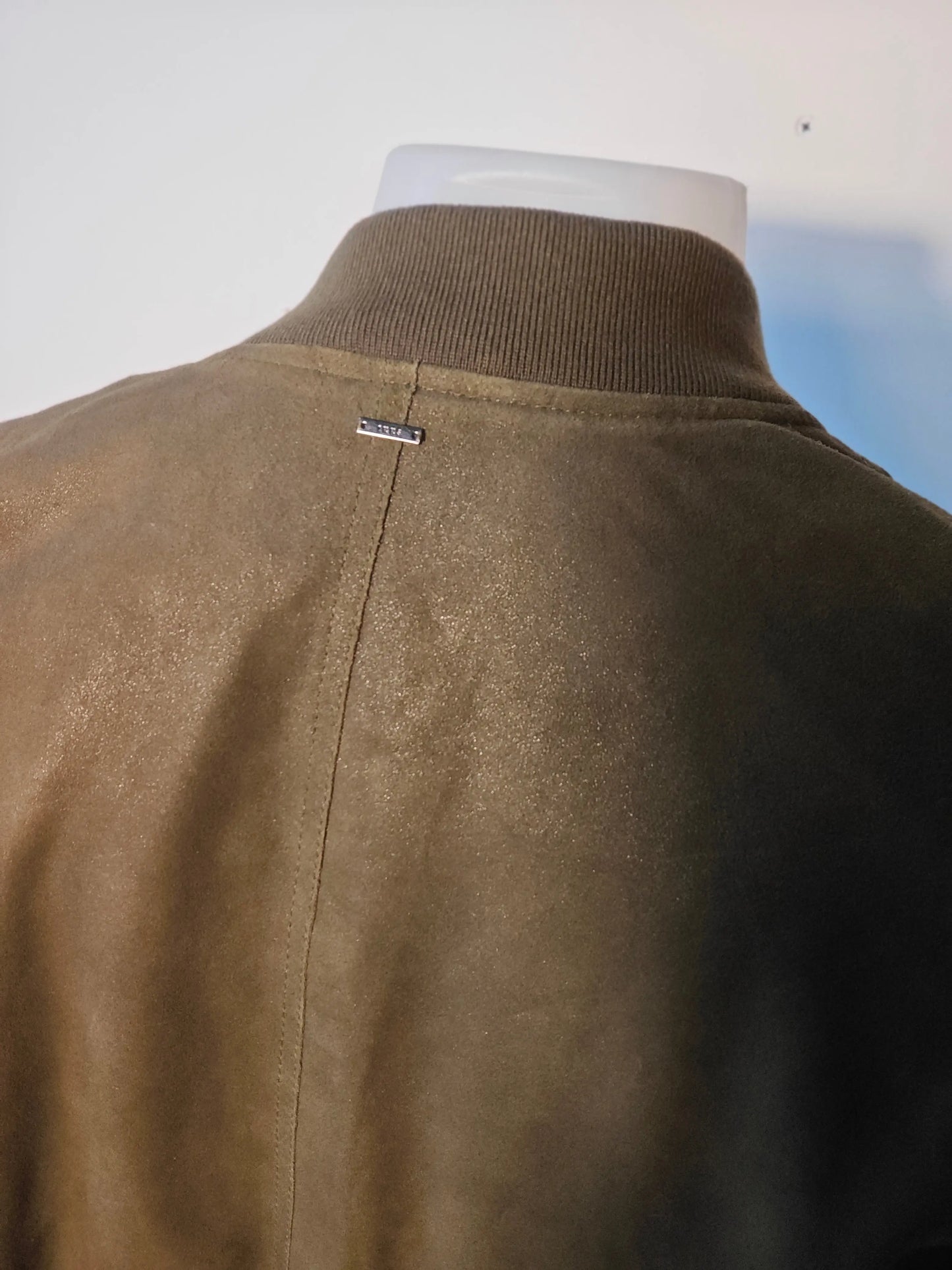 Blouson en cuir kaki IKKS avec col montant côtelé, détail métallique sur la couture centrale au dos.