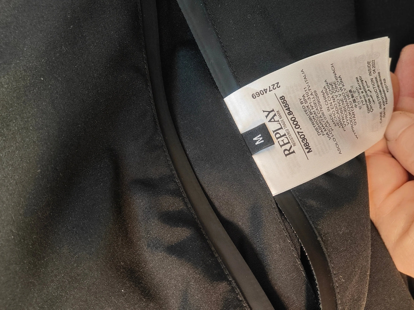 Veste réversible kaki et noire, taille M, de Replay, avec étiquette d'entretien visible.