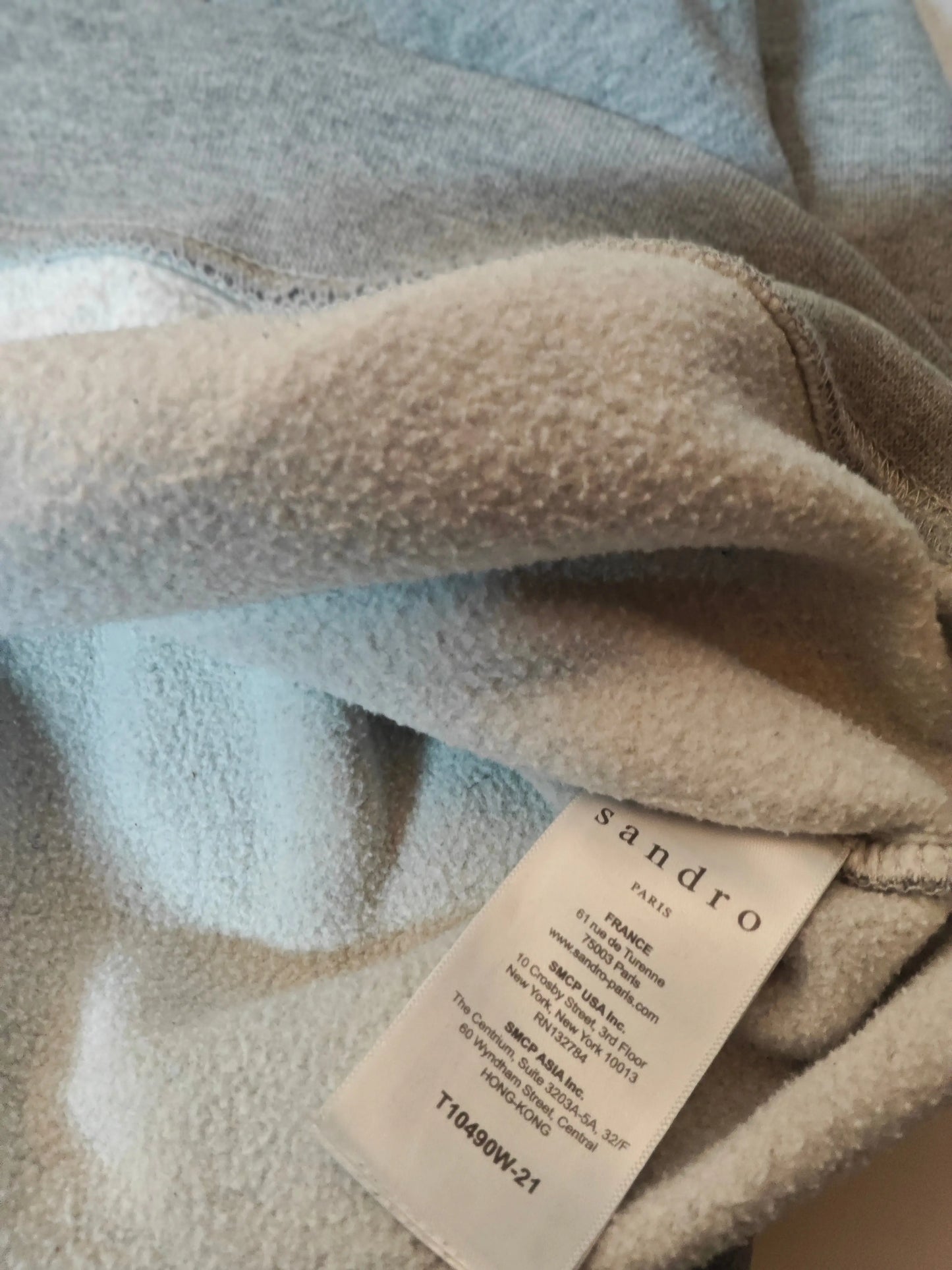 Sweat à capuche gris de Sandro, avec étiquette de la marque visible.
