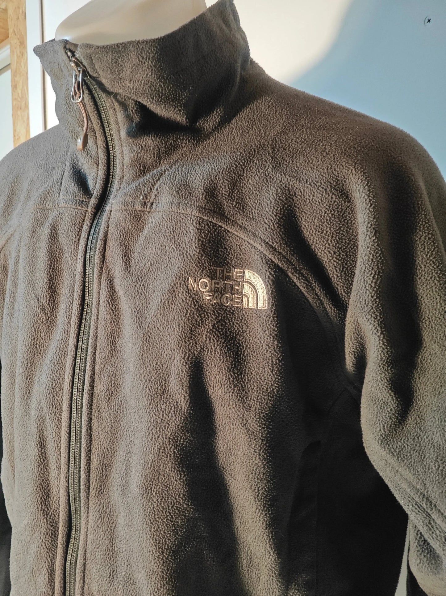 Polaire grise zippée par The North Face, avec logo brodé sur la poitrine.