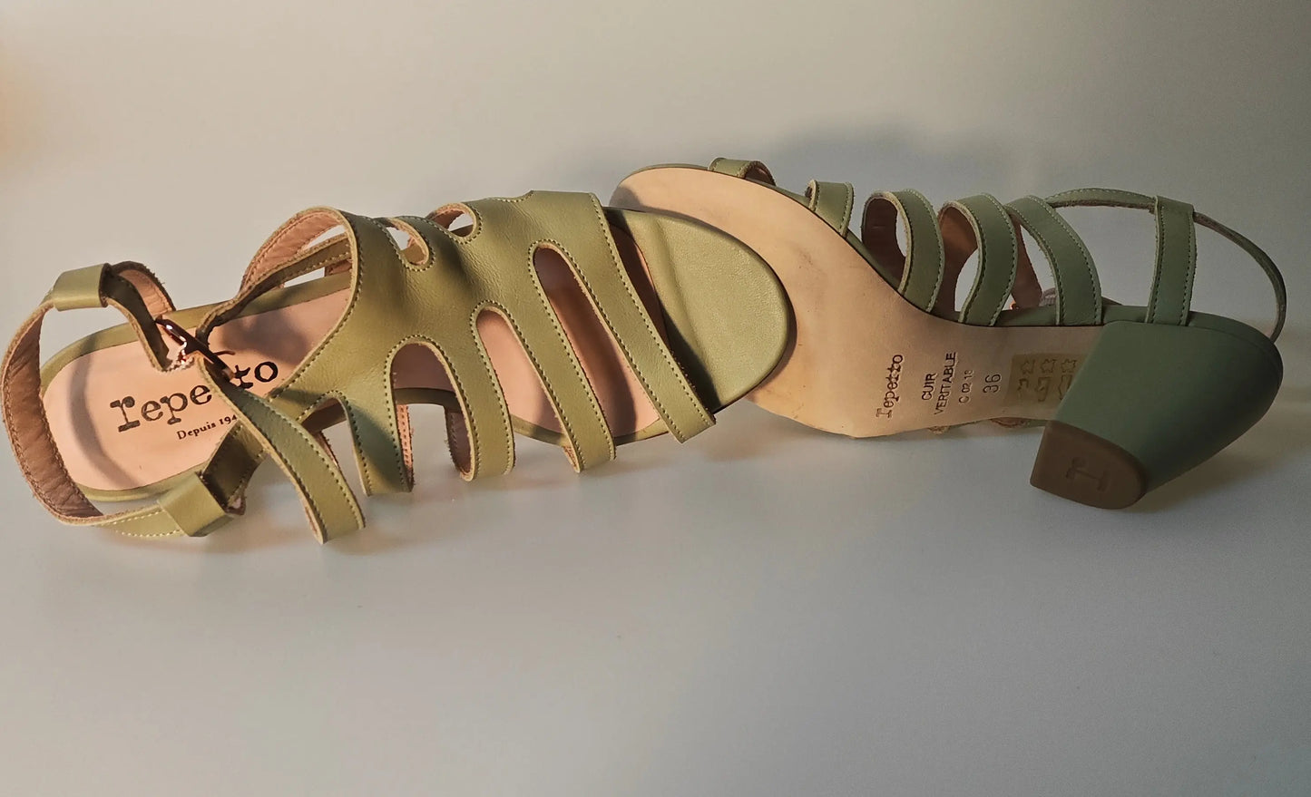 Sandales à talons en cuir vert olive de Repetto, avec des découpes graphiques et une semelle intérieure rose.