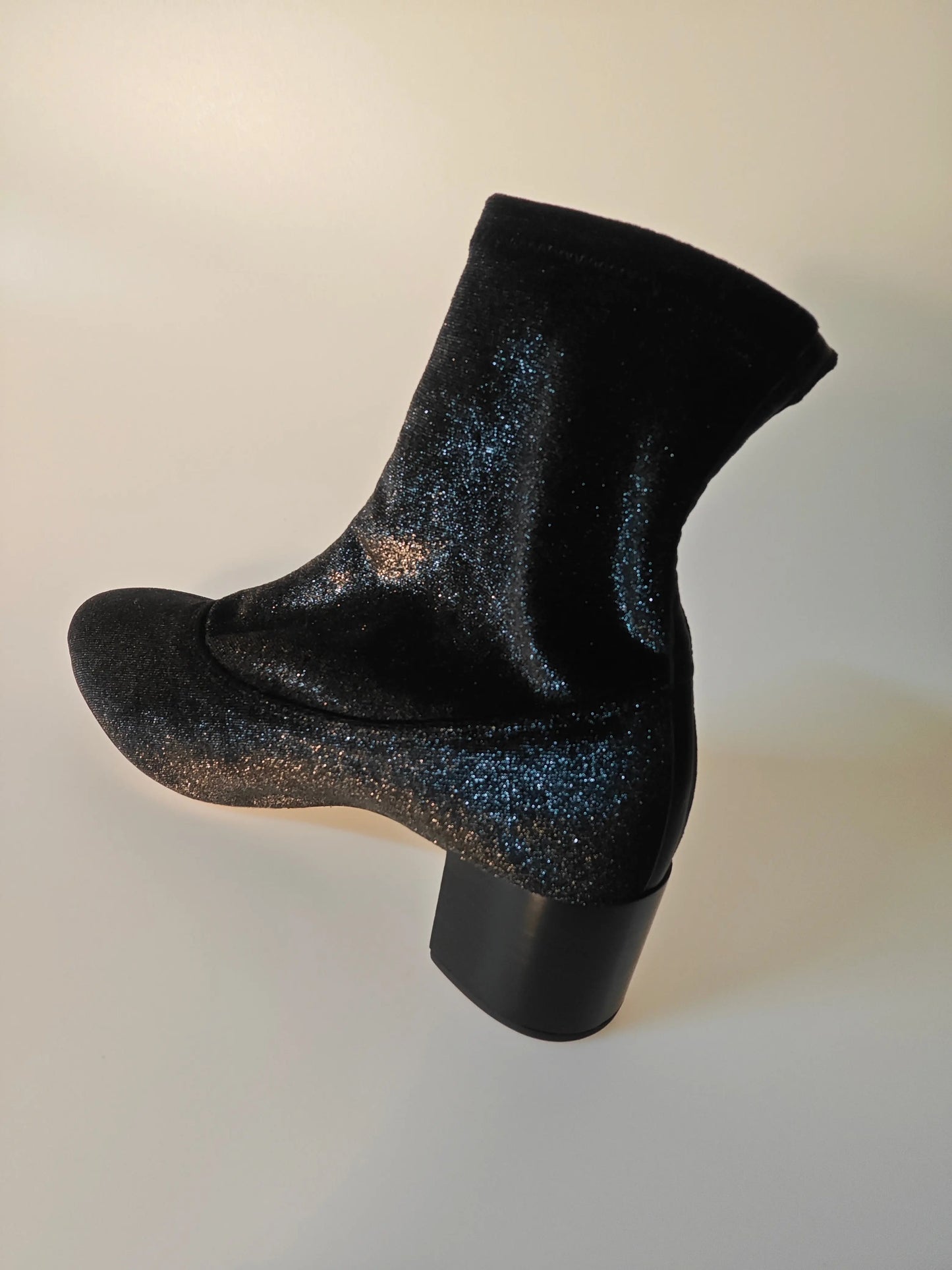 Bottine noire à paillettes by Repetto, avec talon bloc carré et tige montante élastiquée, vue de côté.
