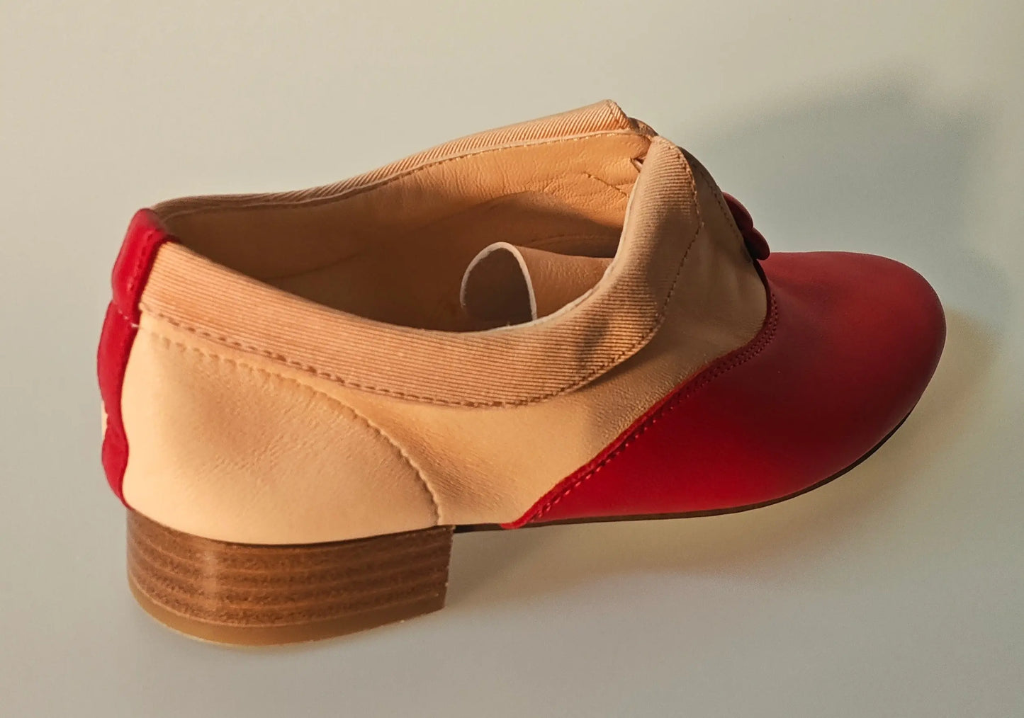 Richelieu rouge et nude Repetto, avec talon bloc bas et détail de couture visible.