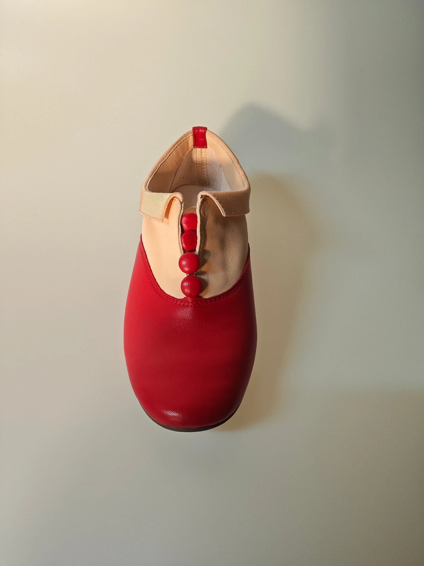 Richelieu Zizi rouge et beige Repetto, ornée de trois boutons rouges, présentée vue de dessus.