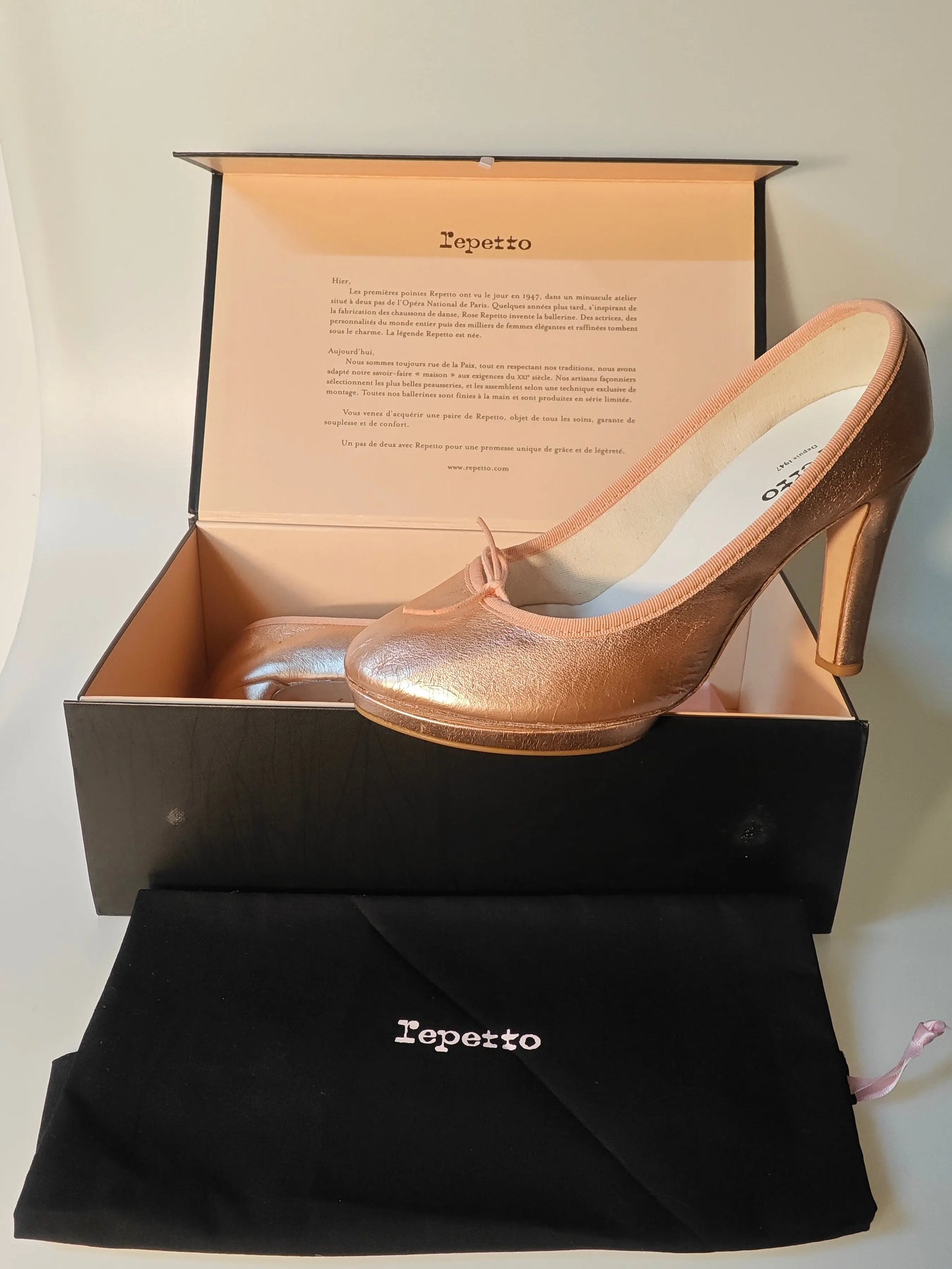 Escarpins en cuir rose cuivré, modèle iconique, de Repetto, présentés dans leur boîte avec un sac de rangement.