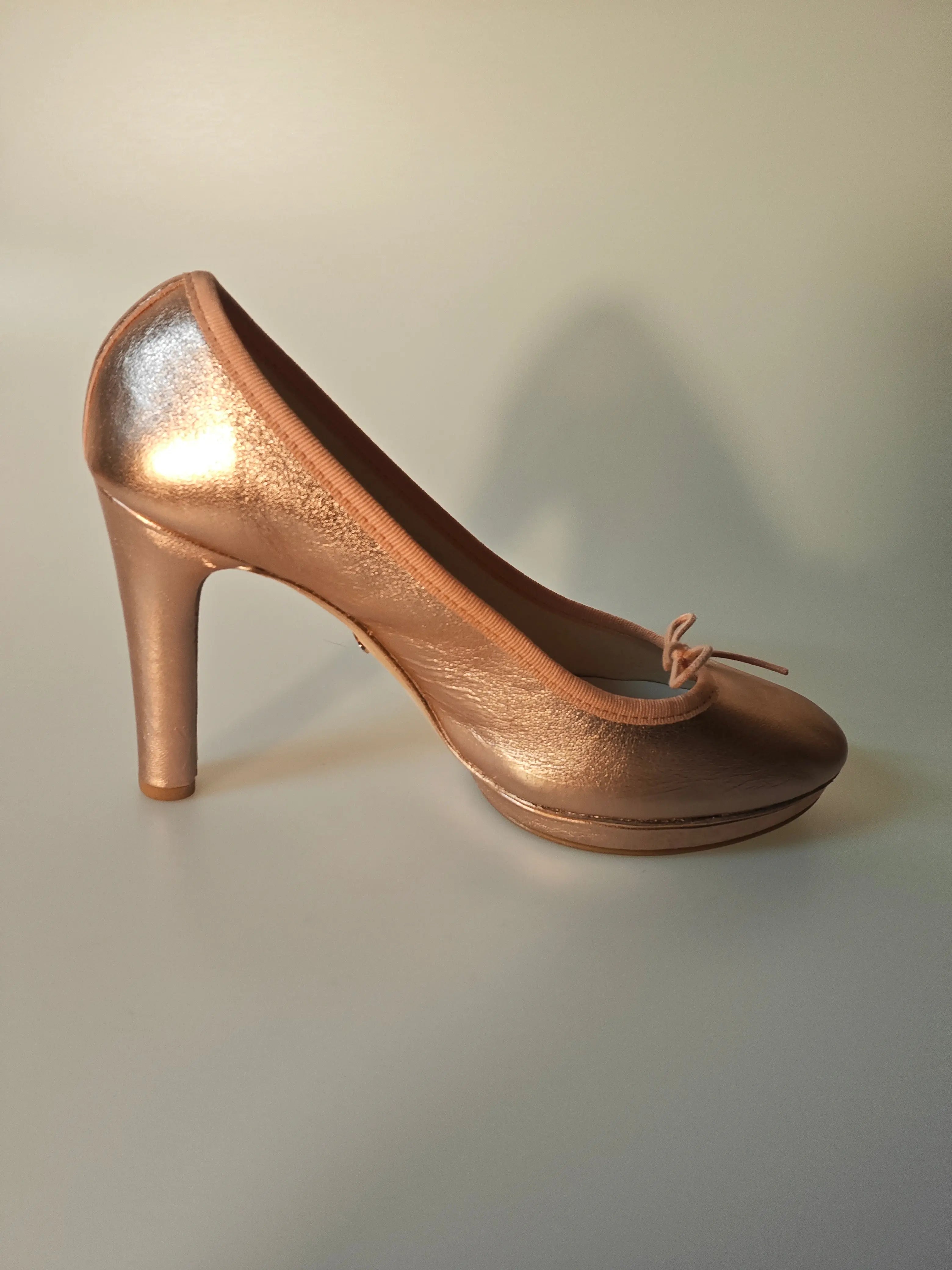 Escarpin Repetto iconique en cuir rose cuivré de Repetto, avec petit nœud décoratif sur le devant.