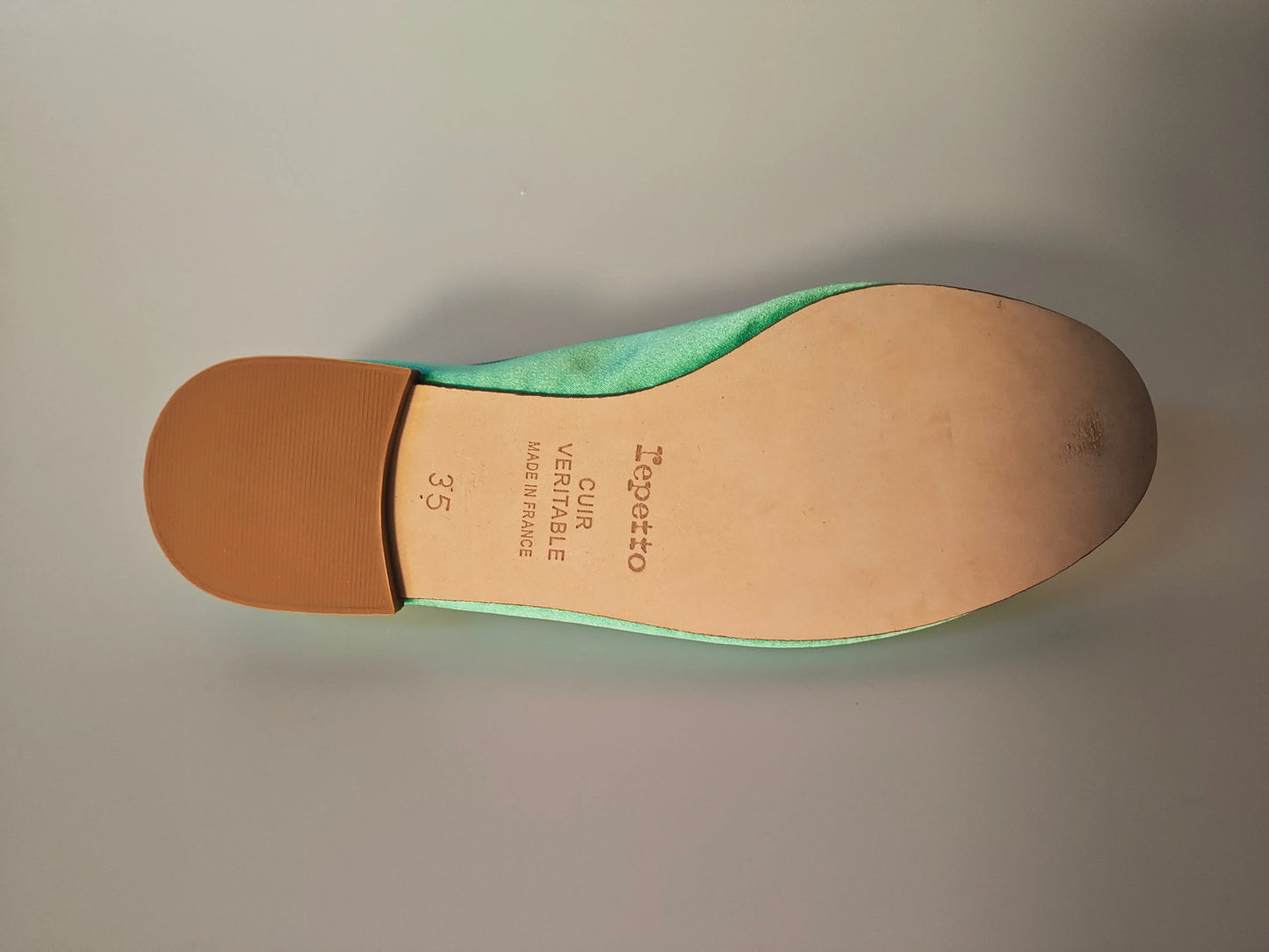 Ballerine en satin vert émeraude de Repetto, montrant la semelle en cuir avec le logo et la pointure.