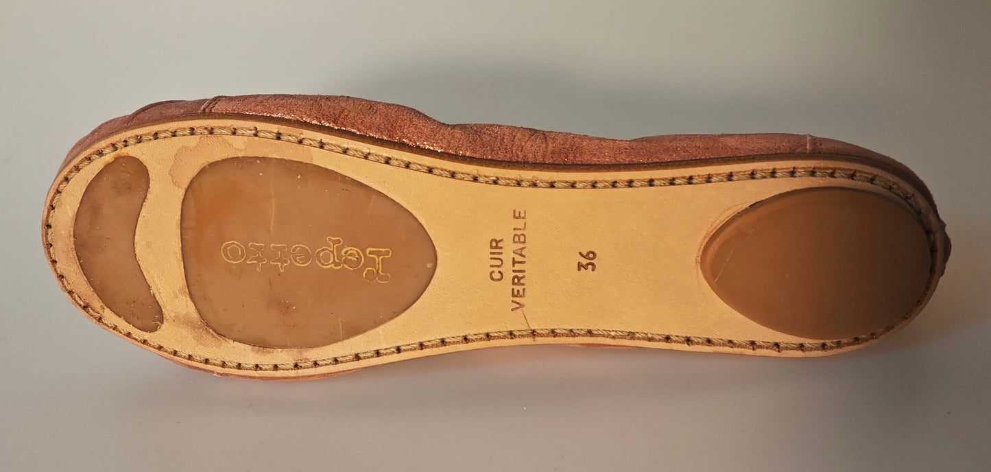 Ballerine plate rose poudré de Repetto, montrant la semelle en cuir avec couture apparente et logo imprimé.