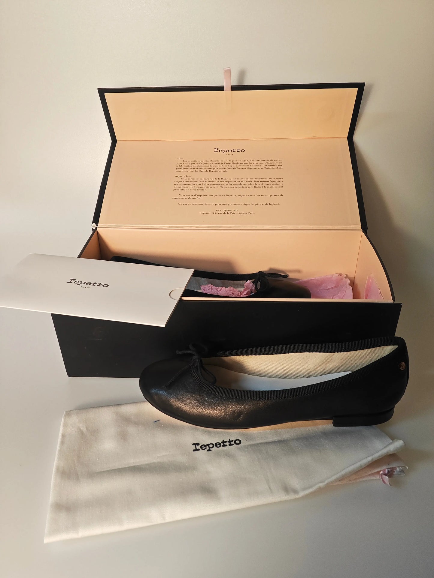 Ballerine noire en cuir véritable de Repetto, présentées dans leur boîte avec un sac de rangement.