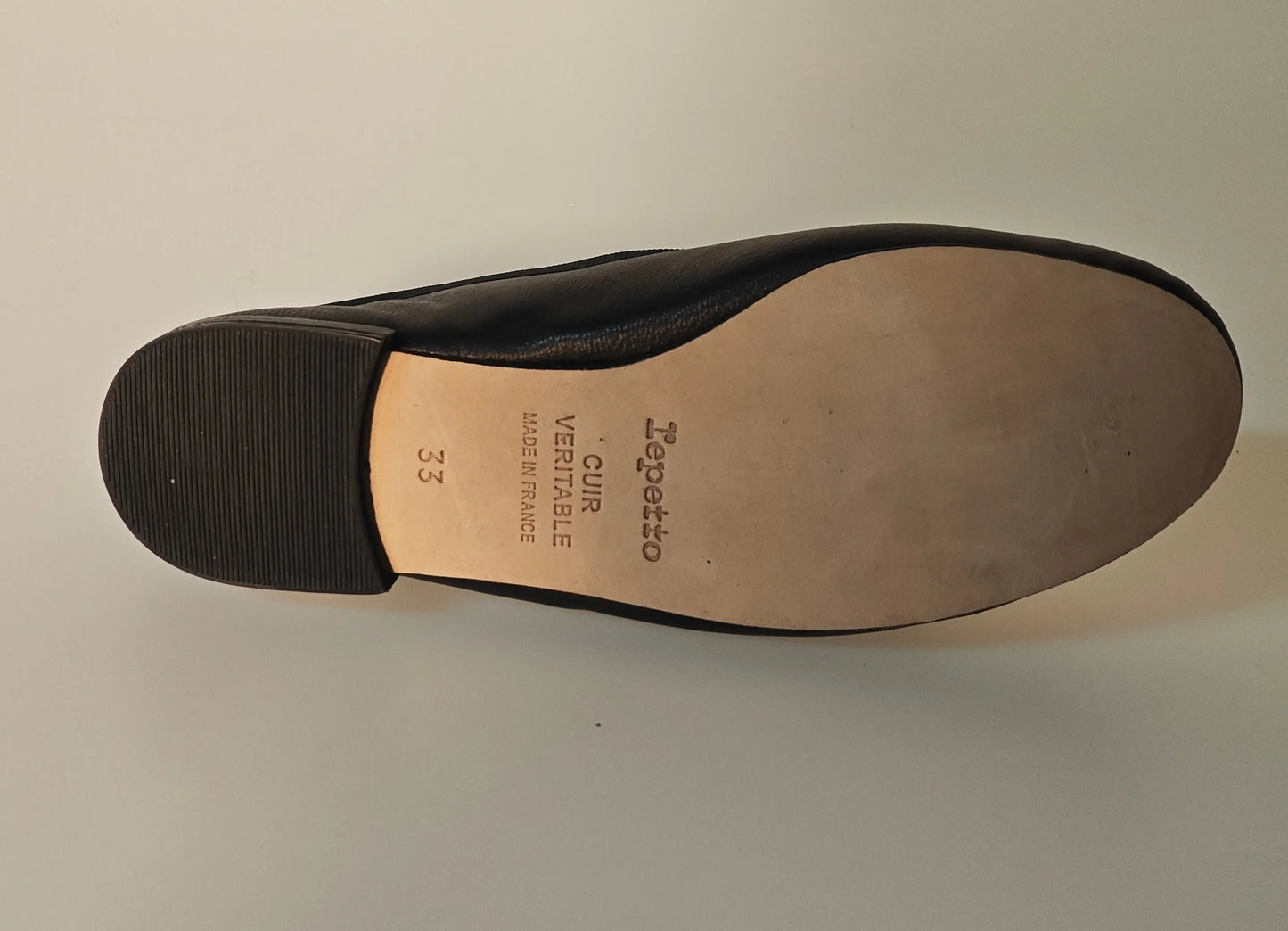 Ballerine noire en cuir véritable de Repetto, semelle beige et talonnette noire.