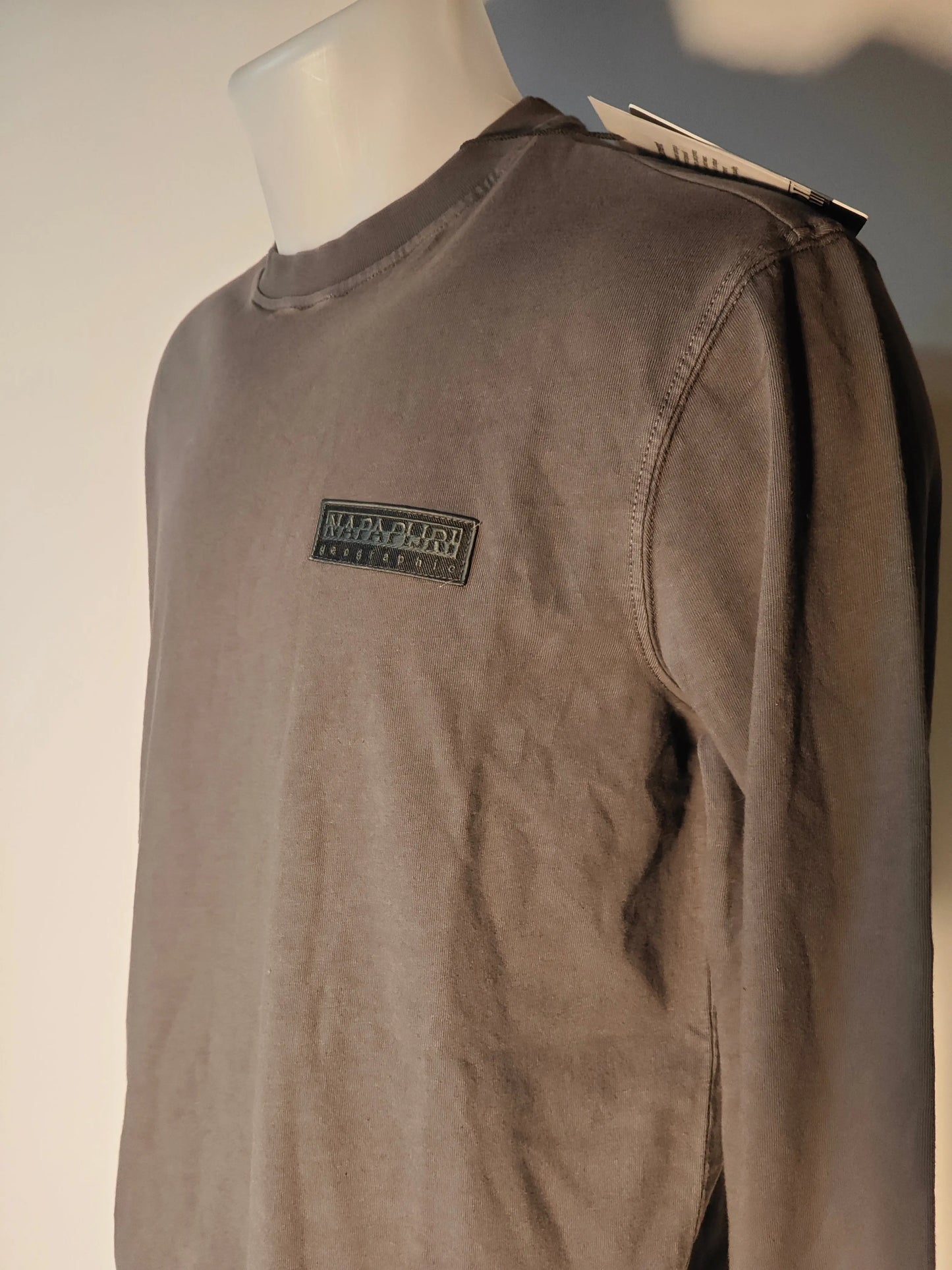 Sweat-shirt gris foncé uni de Napapijri, présenté sur un mannequin, avec une étiquette visible au col.