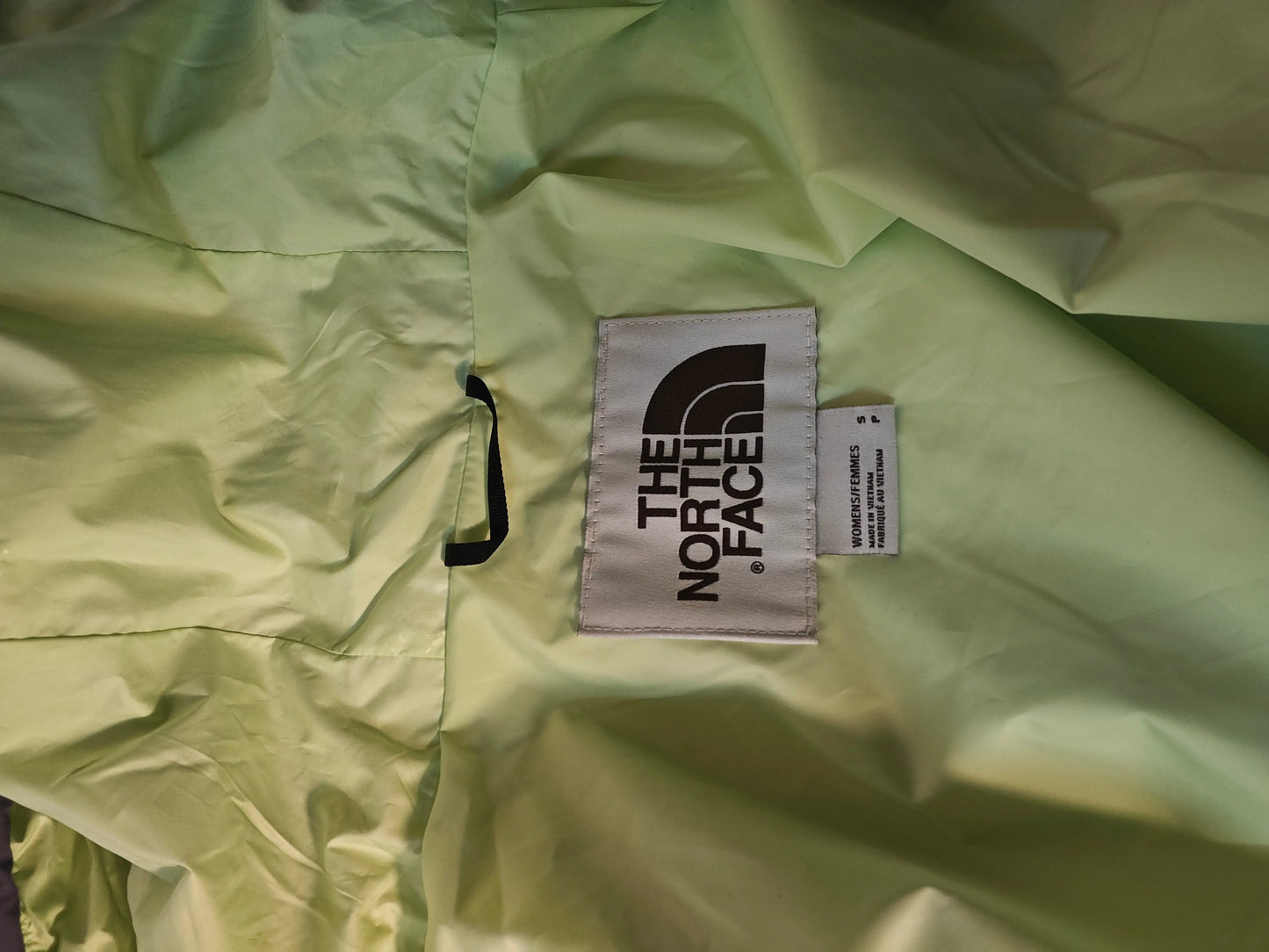 Veste de femme lavande et menthe de The North Face, avec étiquette de taille visible.