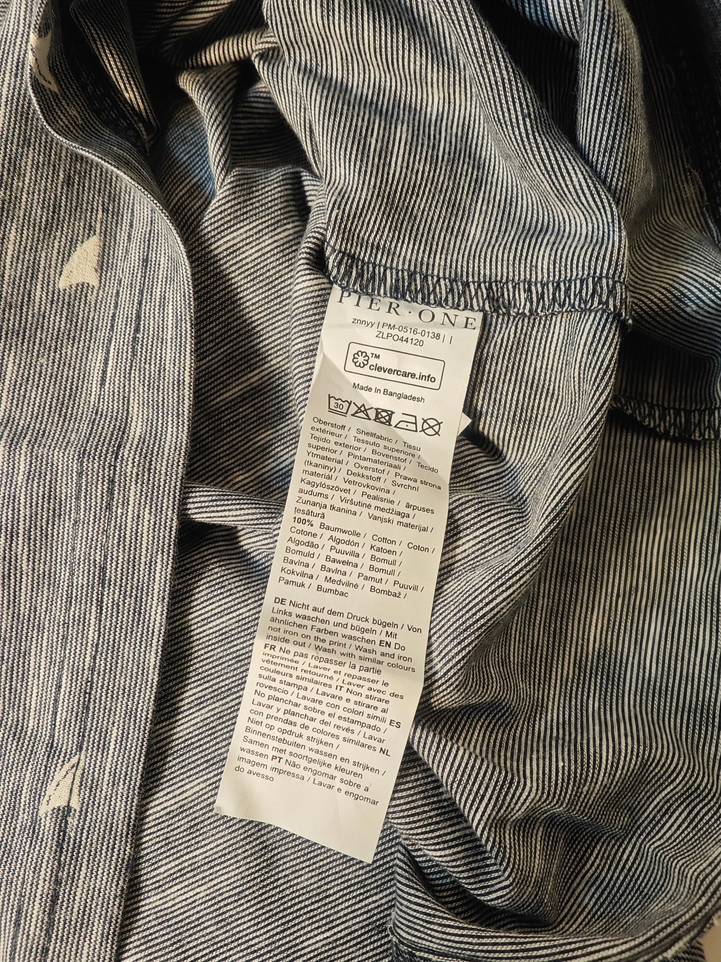 T-shirt gris à motif voiliers par Pier One, avec étiquette d'entretien visible.