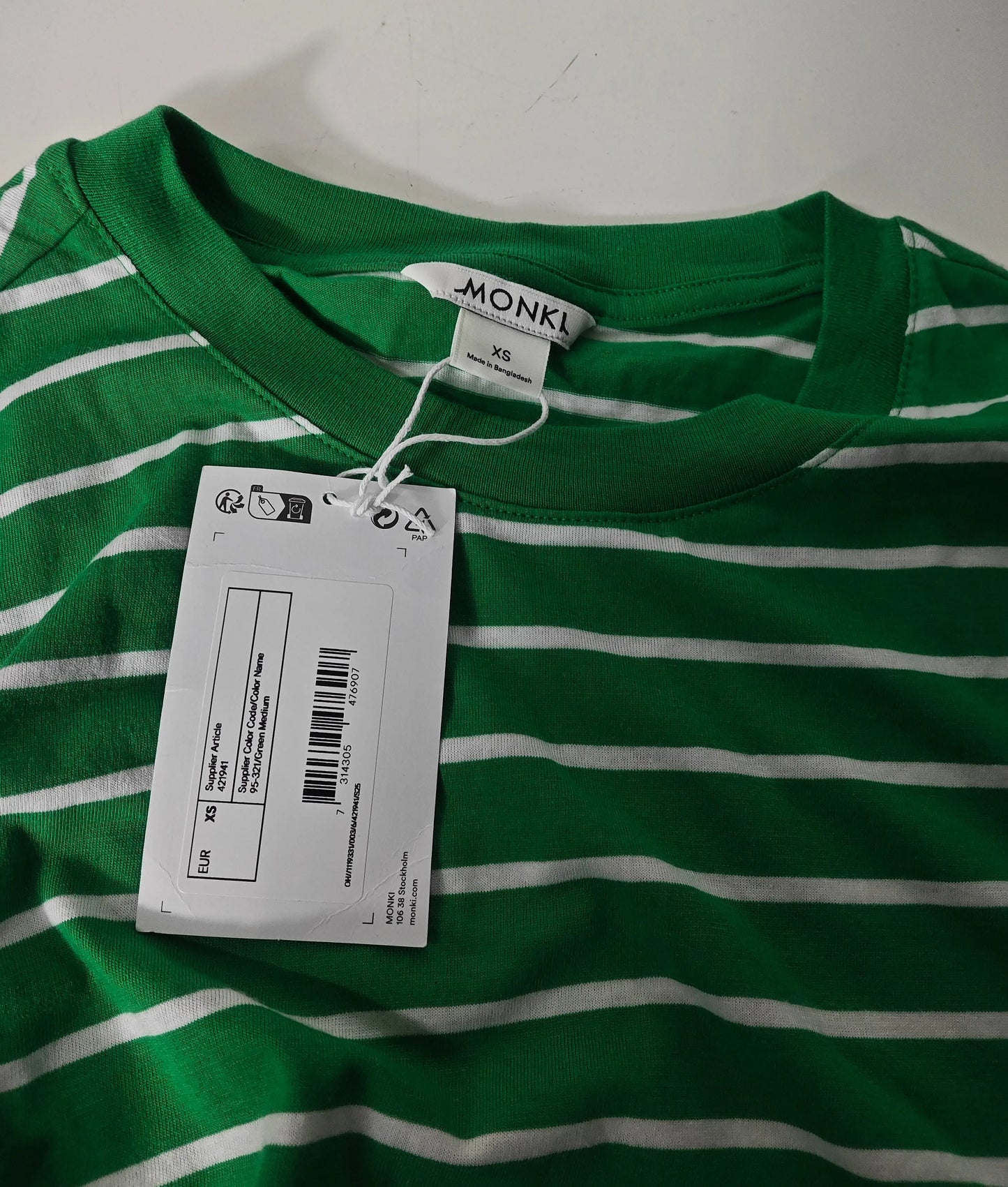 T-shirt rayé vert et blanc à manches longues de Monki, avec une étiquette.