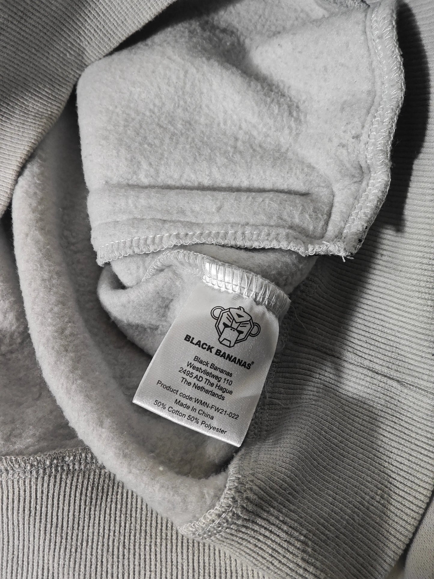 Hoodie gris clair de Black Bananas, avec logo rose, en coton et polyester, fabriqué en Chine.