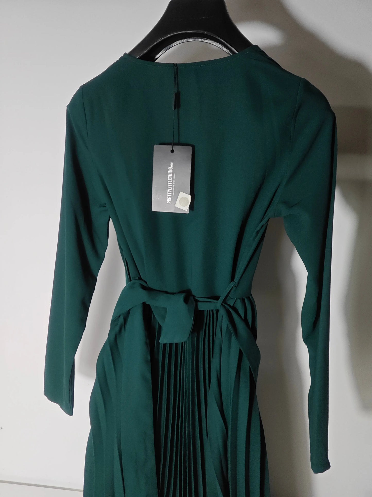 Robe plissée verte par PrettyLittleThing, avec une ceinture nouée et une jupe plissée à fines rayures.