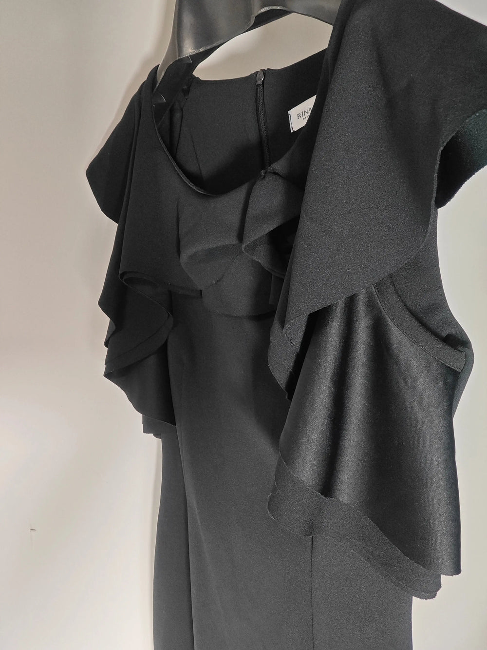 Robe noire à volants par Rinascimento, confectionnée en Italie, sur un cintre.