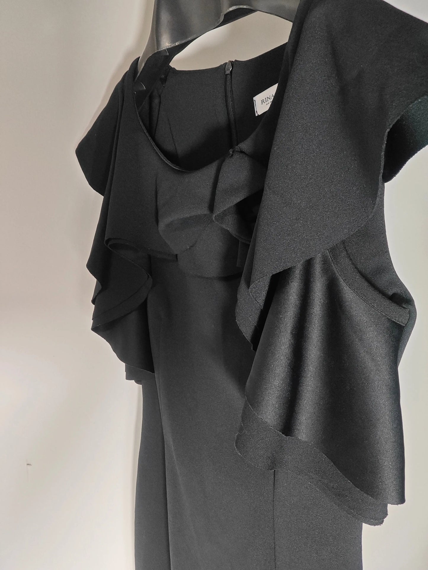 Robe noire à volants par Rinascimento, confectionnée en Italie, sur un cintre.