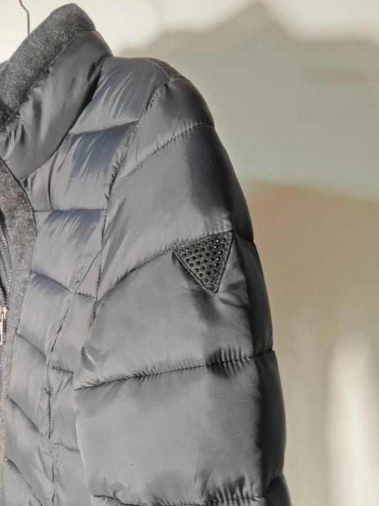 Doudoune longue noire de Guess avec empiècements en laine grise et logo triangulaire à strass.