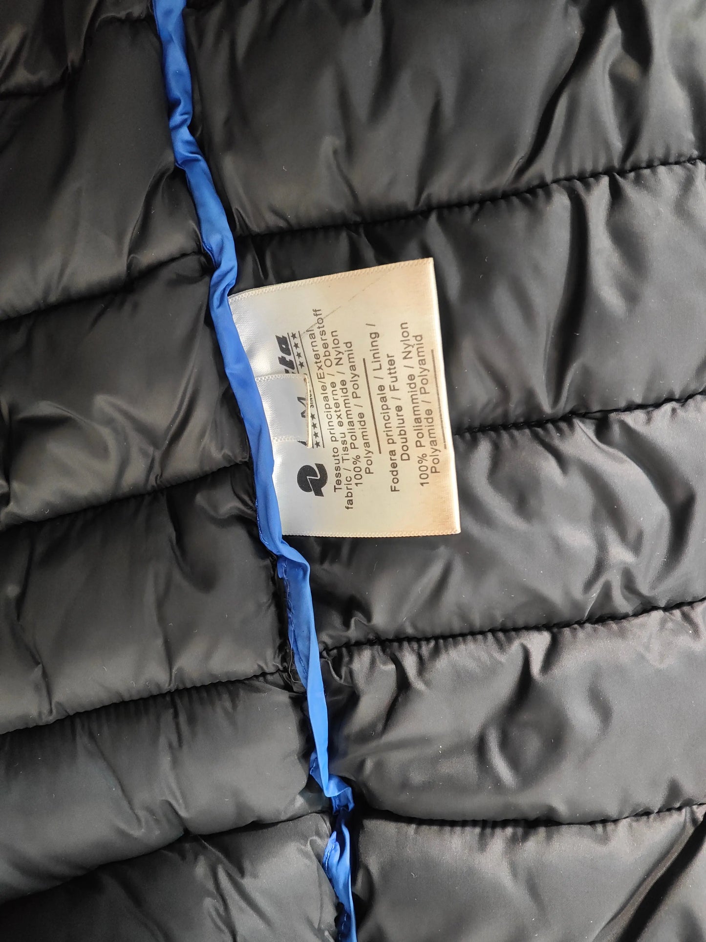 Doudoune Invicta noire de taille M IT, par Invicta, avec une étiquette de composition visible et une bordure bleue.
