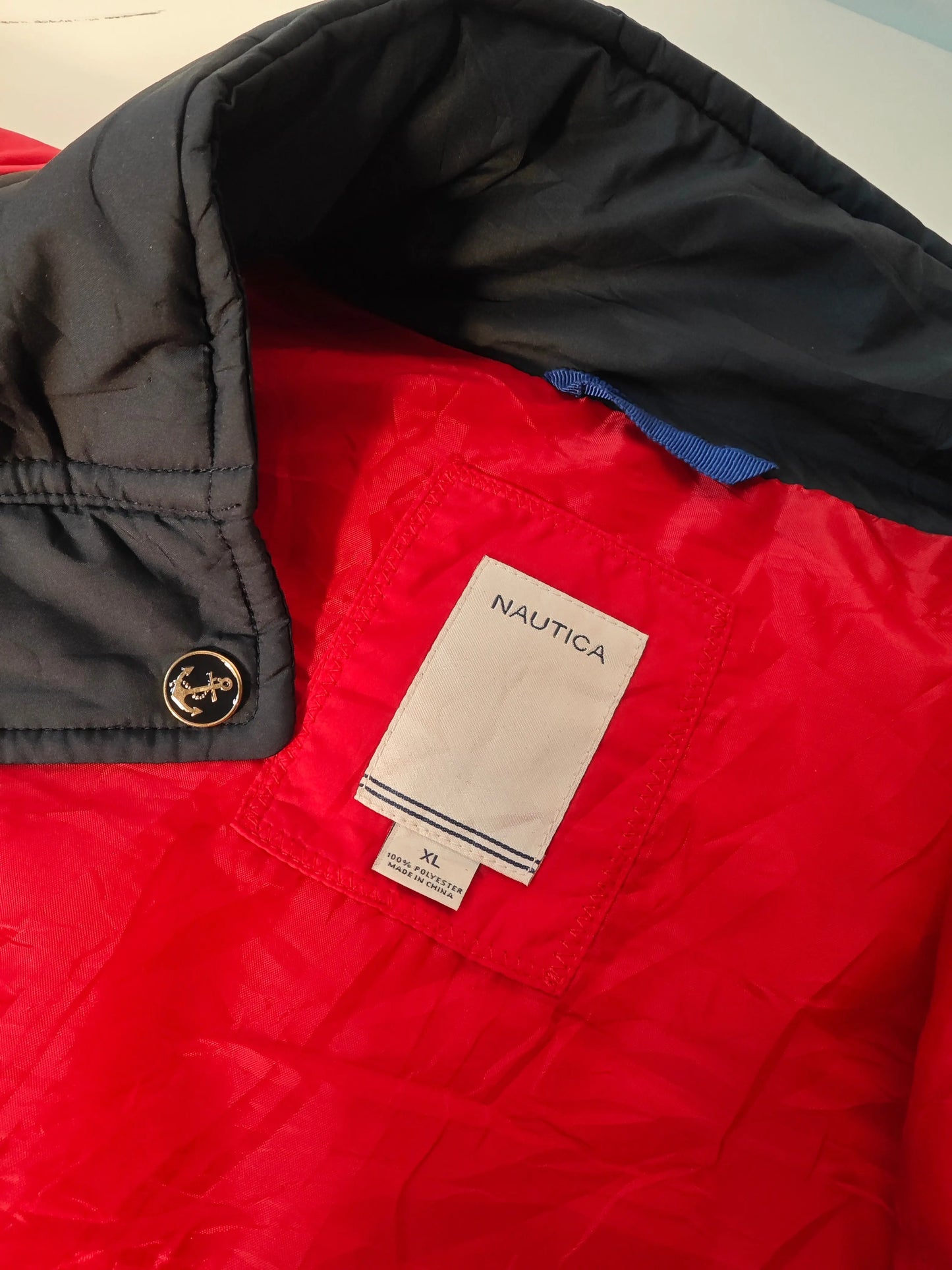 Doudoune rouge et noire, taille XL de Nautica, avec un bouton doré orné d'une ancre.
