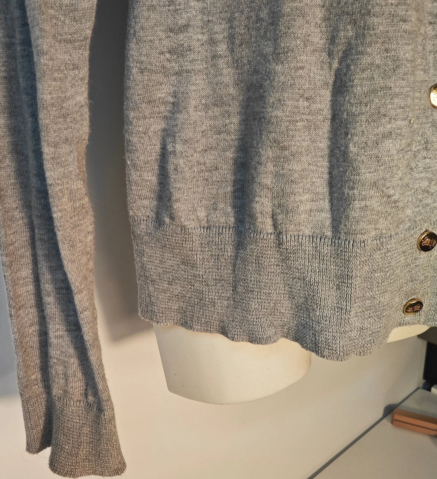 Cardigan gris de Lauren Ralph Lauren avec boutons dorés, présenté sur un mannequin buste.