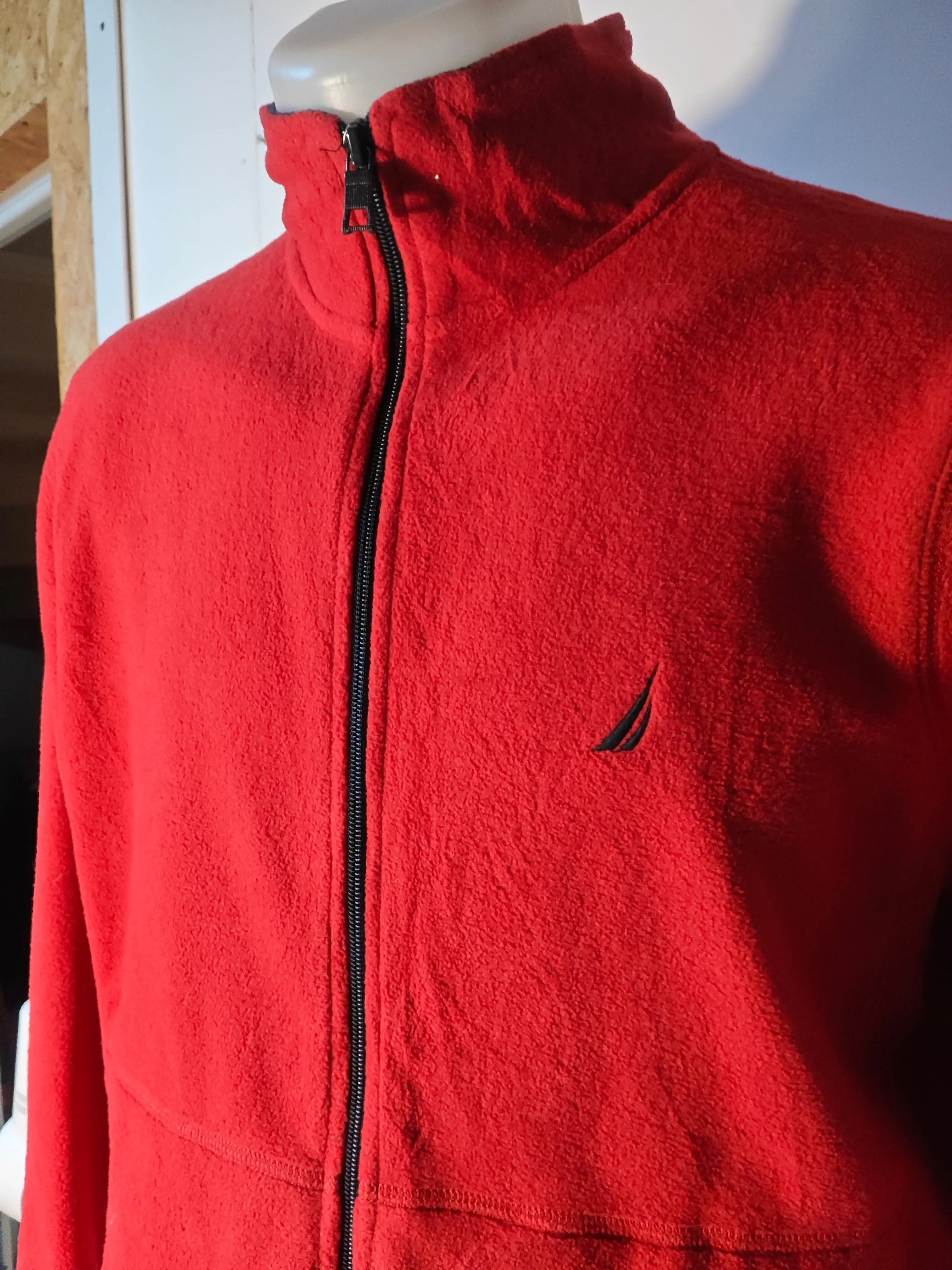 Veste polaire rouge par Nautica, avec fermeture éclair noire et logo sur la poitrine.