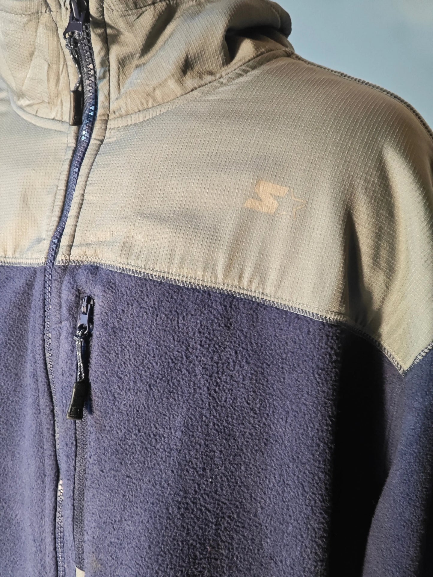 Veste polaire bicolore bleu marine et gris de Sketchers, avec fermeture éclair et logo discret.