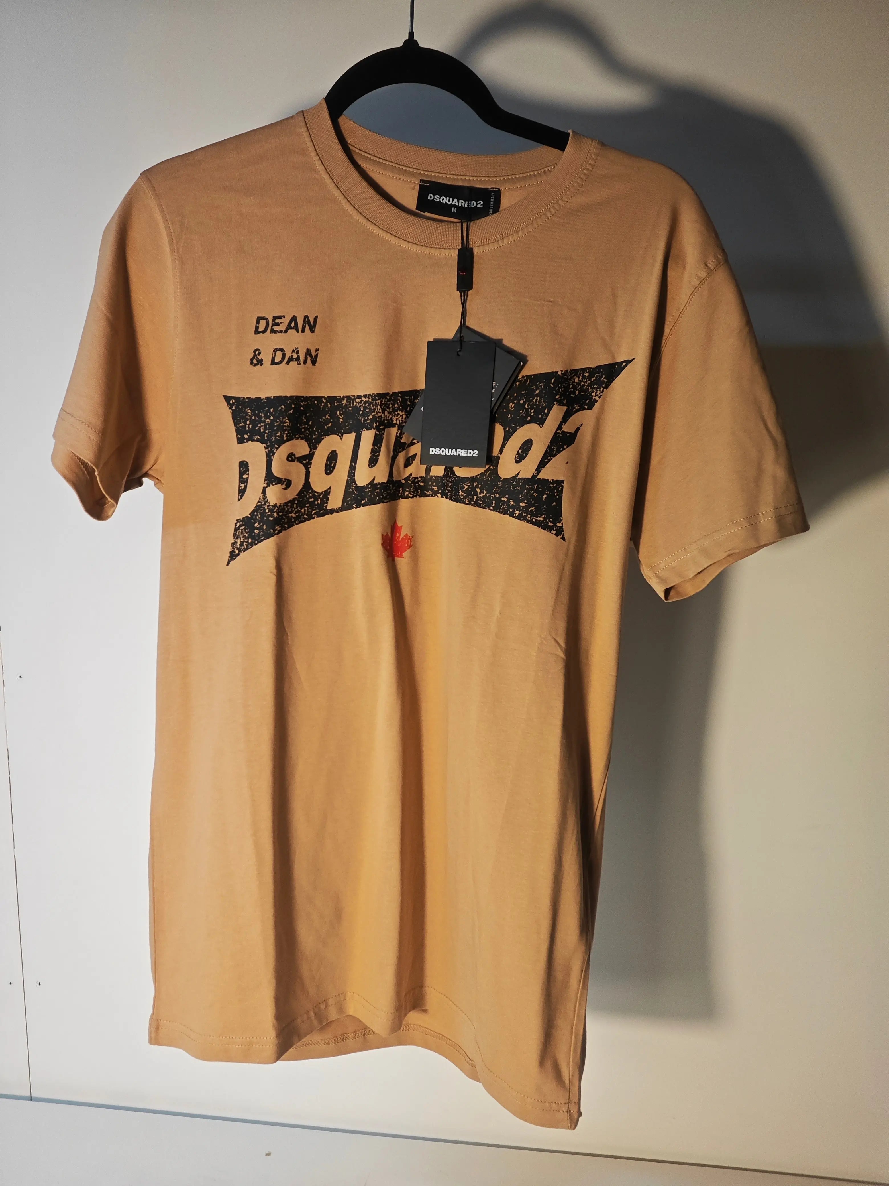T-shirt beige à logo vieilli de Dsquared2 avec imprimé graphique noir et feuille d'érable rouge.