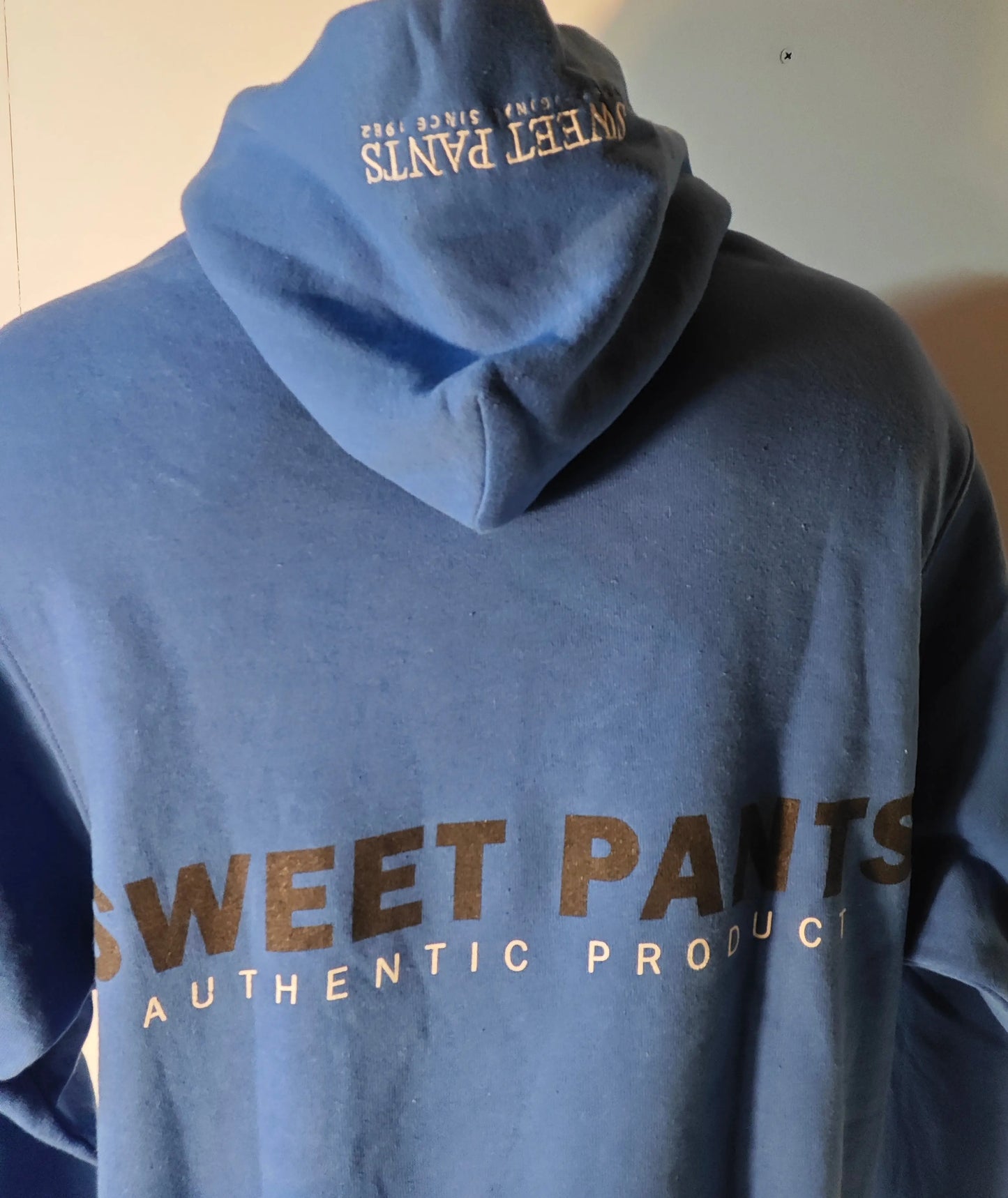 Sweat à capuche oversize bleu de Sweet Pants, avec capuche et inscription graphique contrastée au dos.