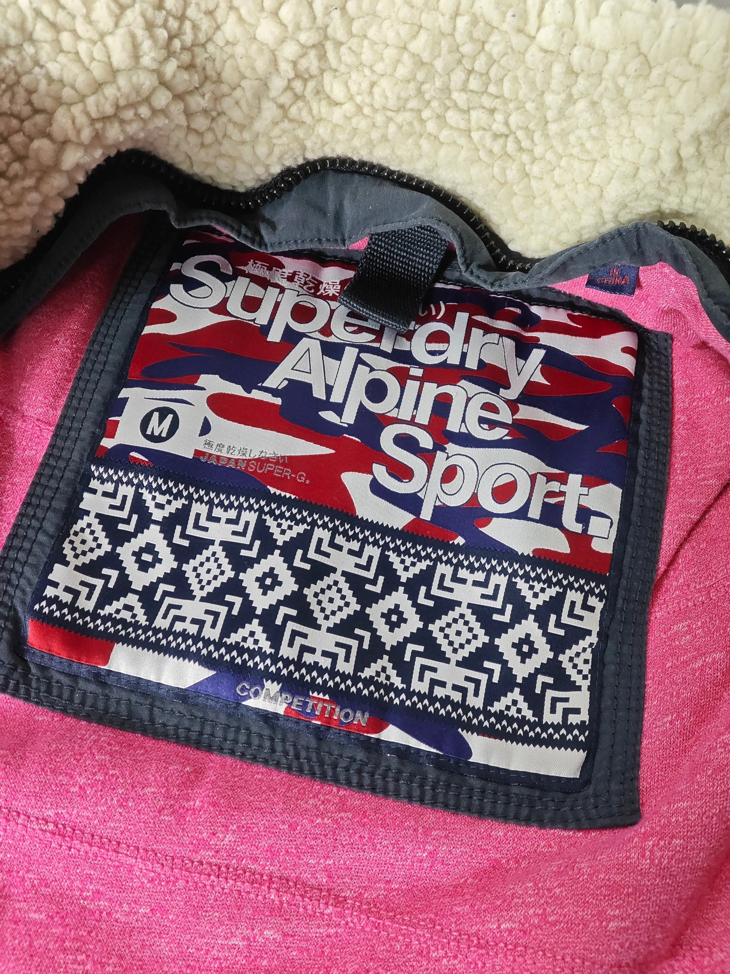 Veste sans manches d'occasion taille M de Superdry, doublure sherpa écrue et étiquette logotypée à motif camouflage.