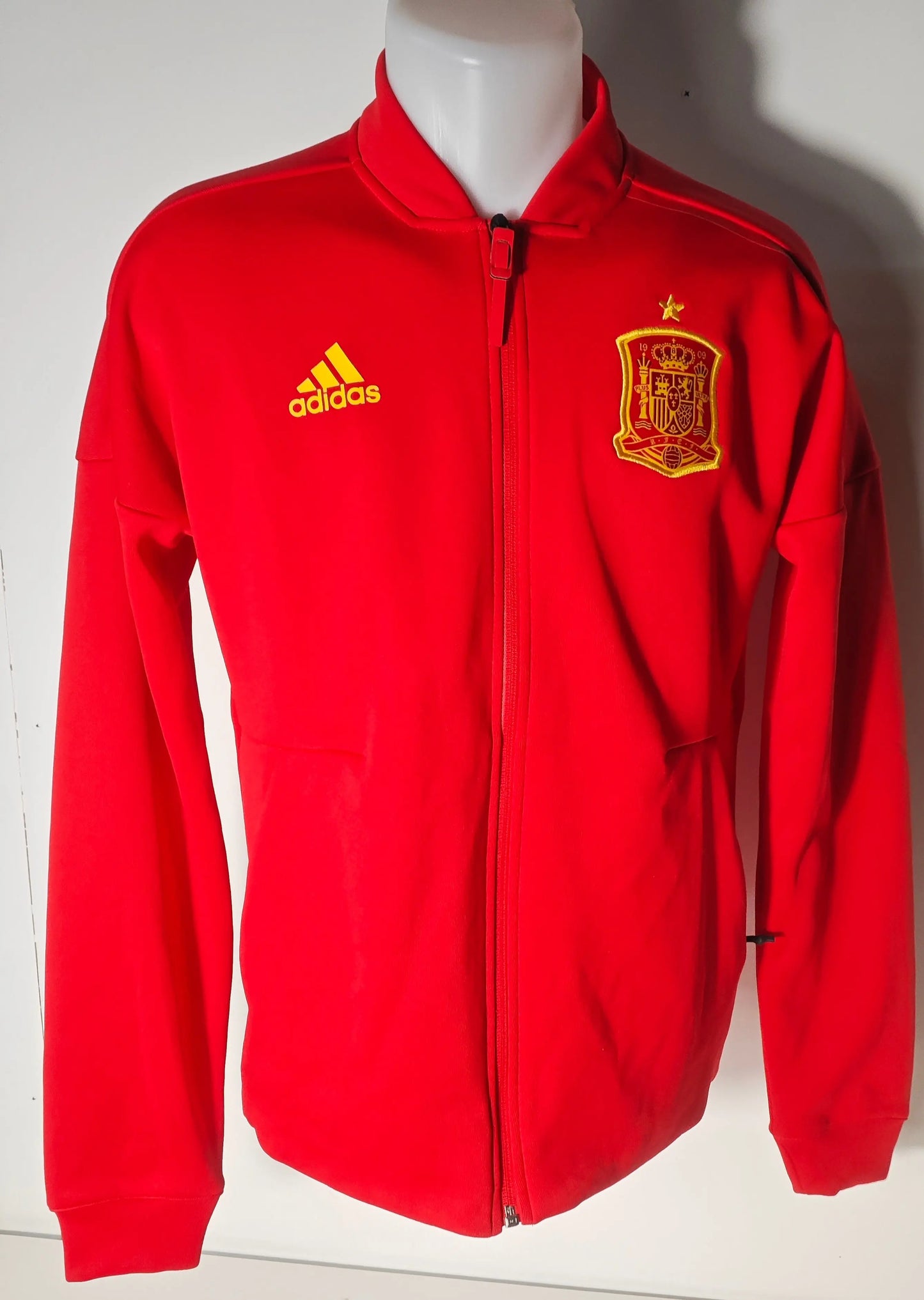 Veste de survêtement rouge par Adidas, écusson de l'Espagne et logo jaune sur le devant, fermeture éclair.